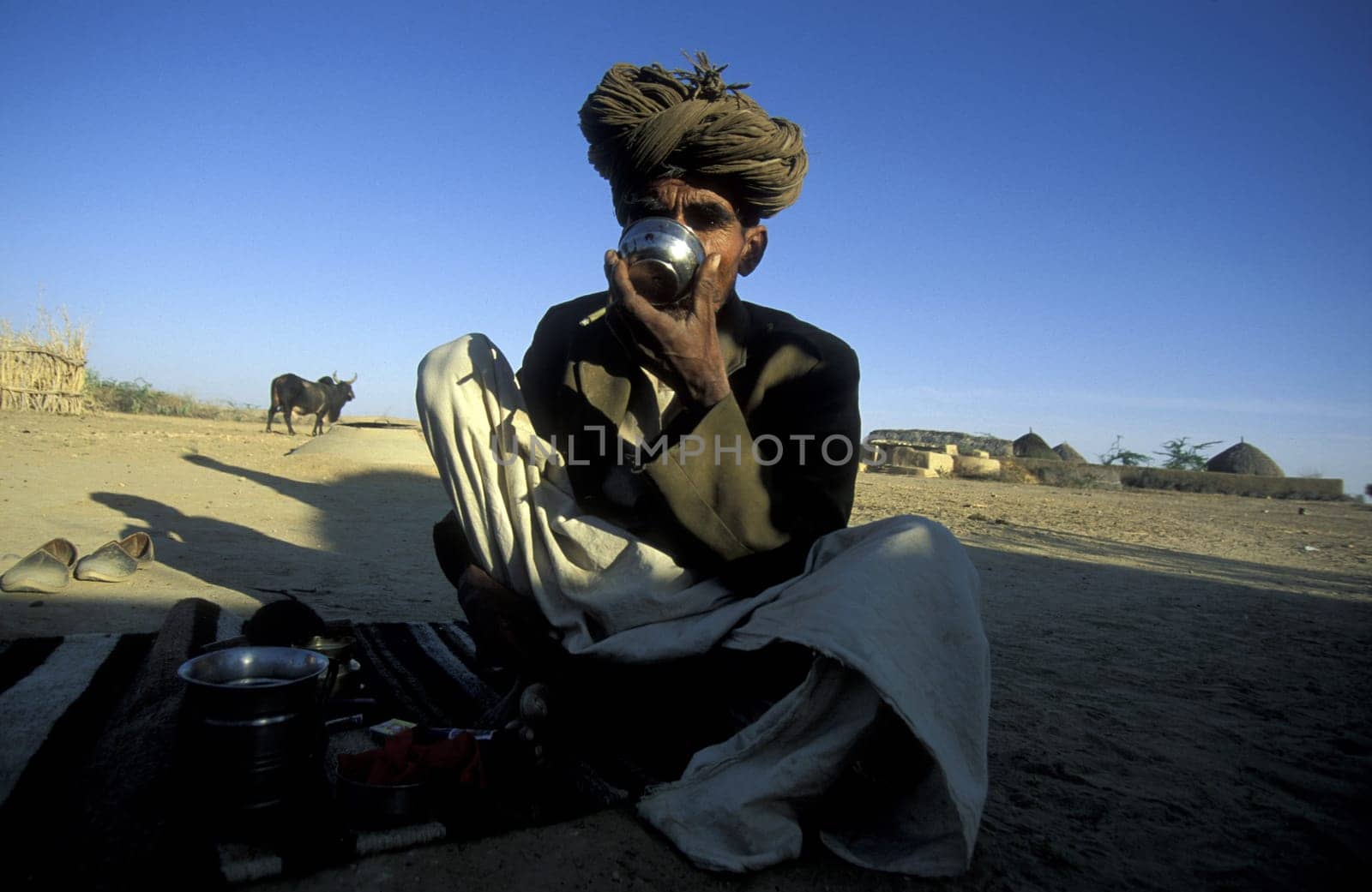 a men drinks water in the deset of tar near the town of Barmer in the province Rajasthan in India.