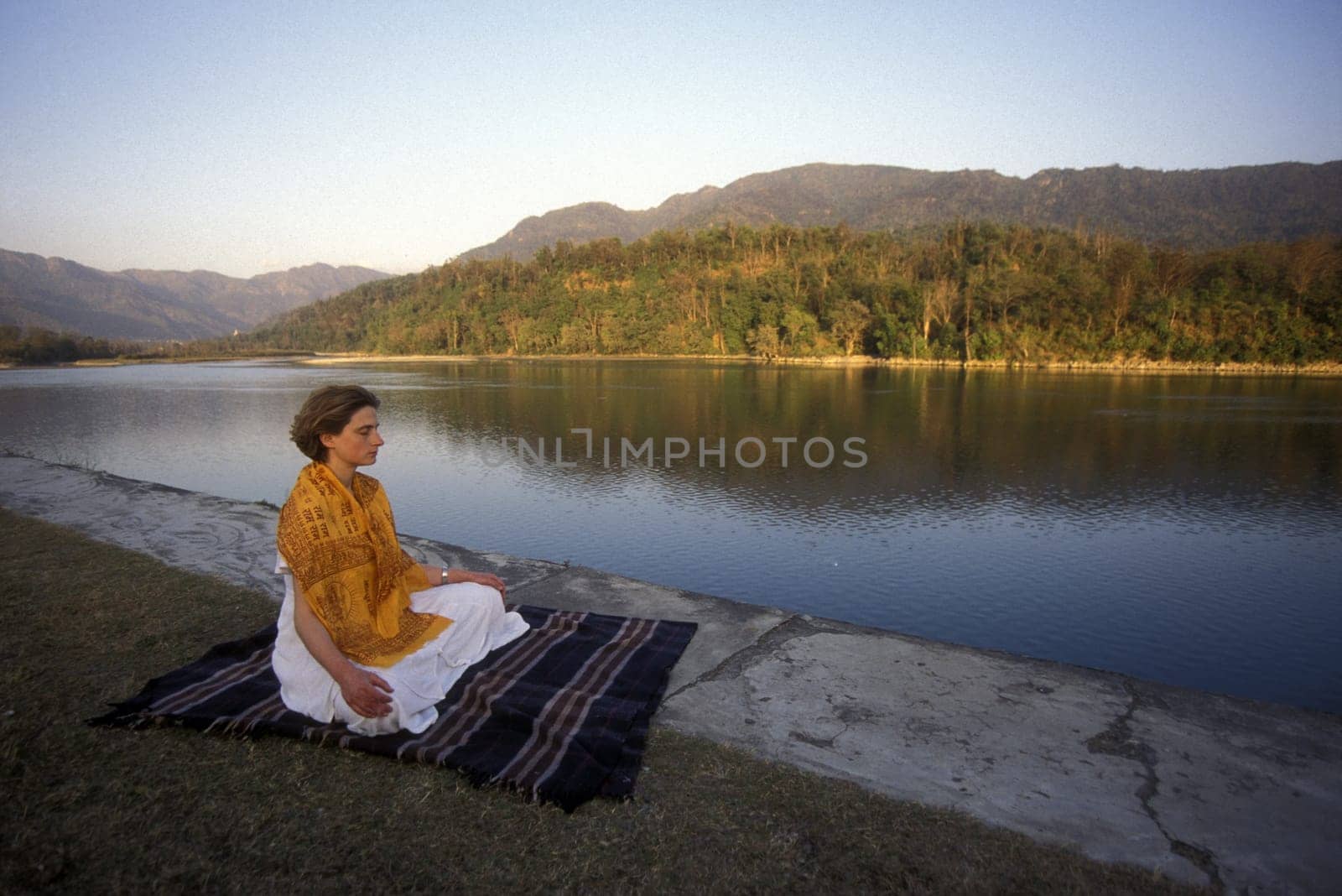 a woman on the Ganges River in the town of Rishikesh in the Province of Uttar Pradesh in India.