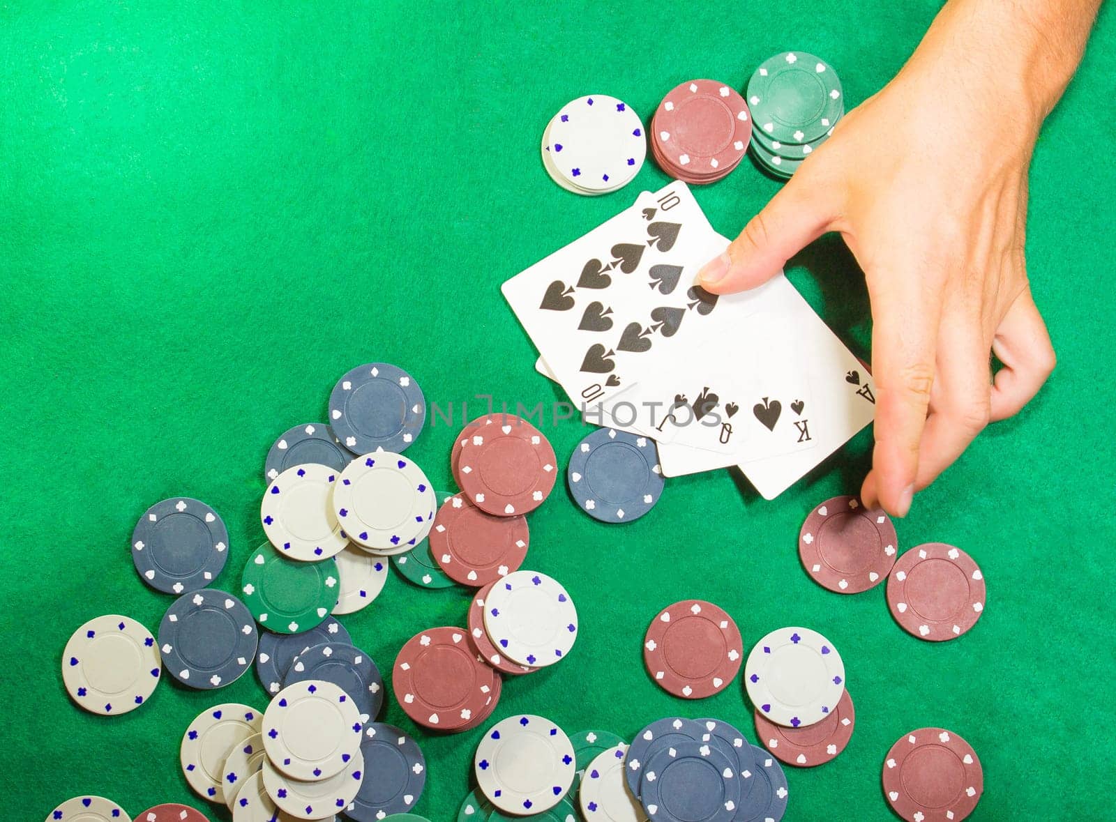 The male hands with cards in casino and chips