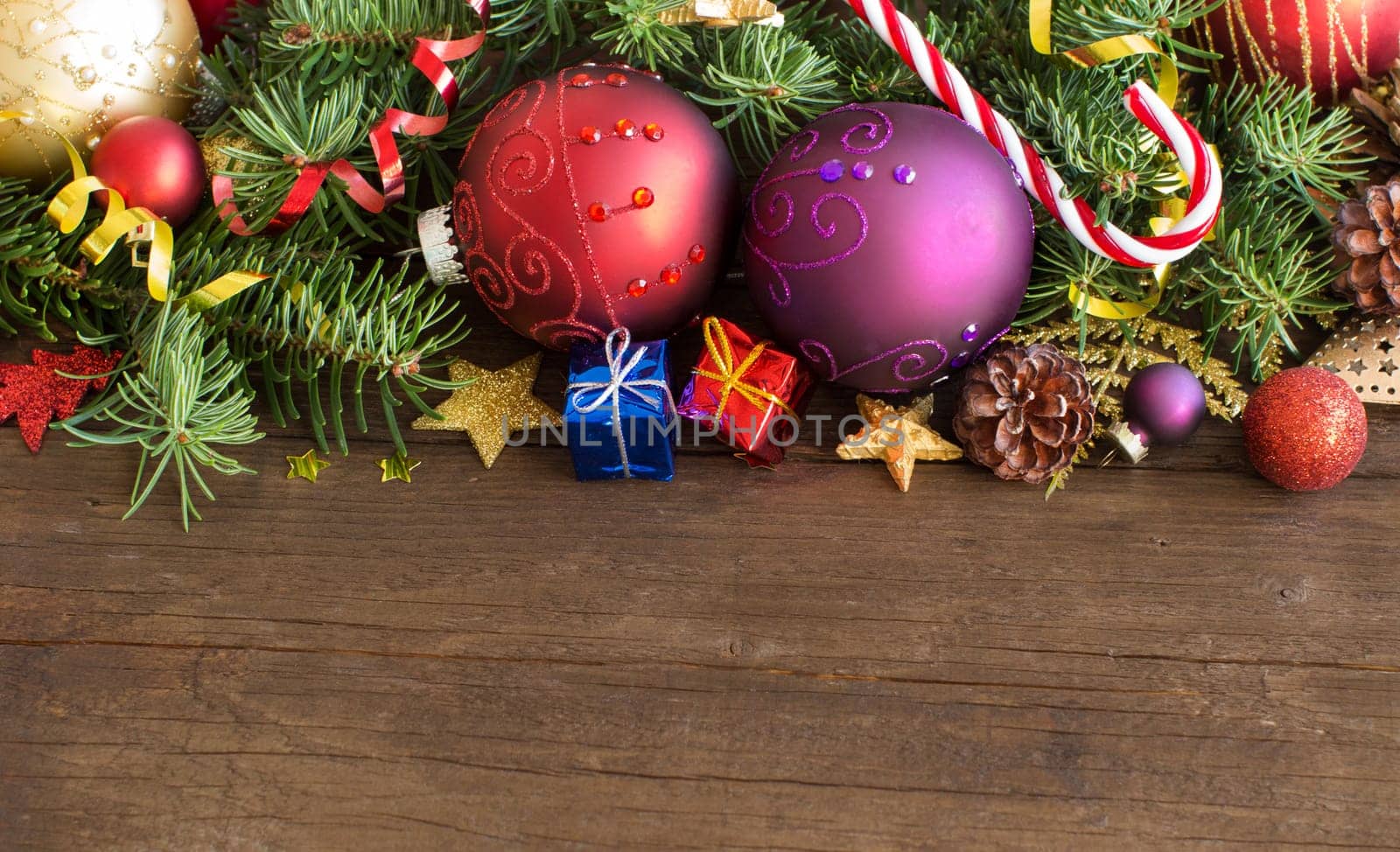 Colorful Christmas decorations - baubles, stars and pine cones on wood
