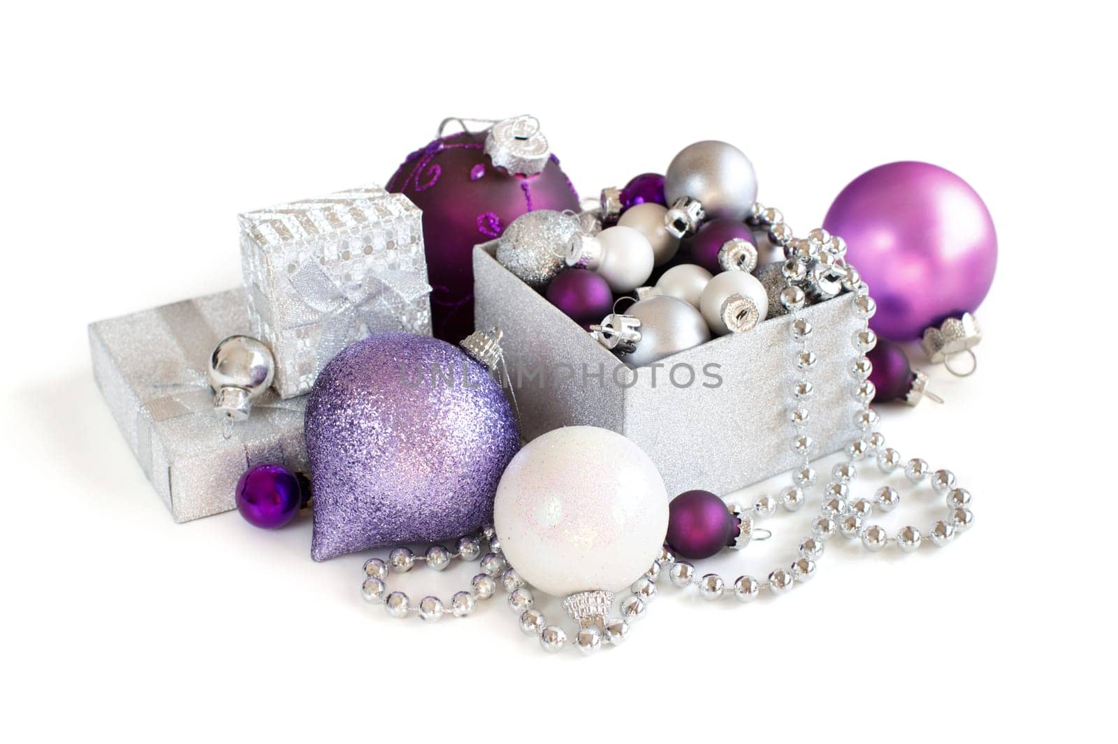 Silver and purple Christmas ornaments in gift box on white background