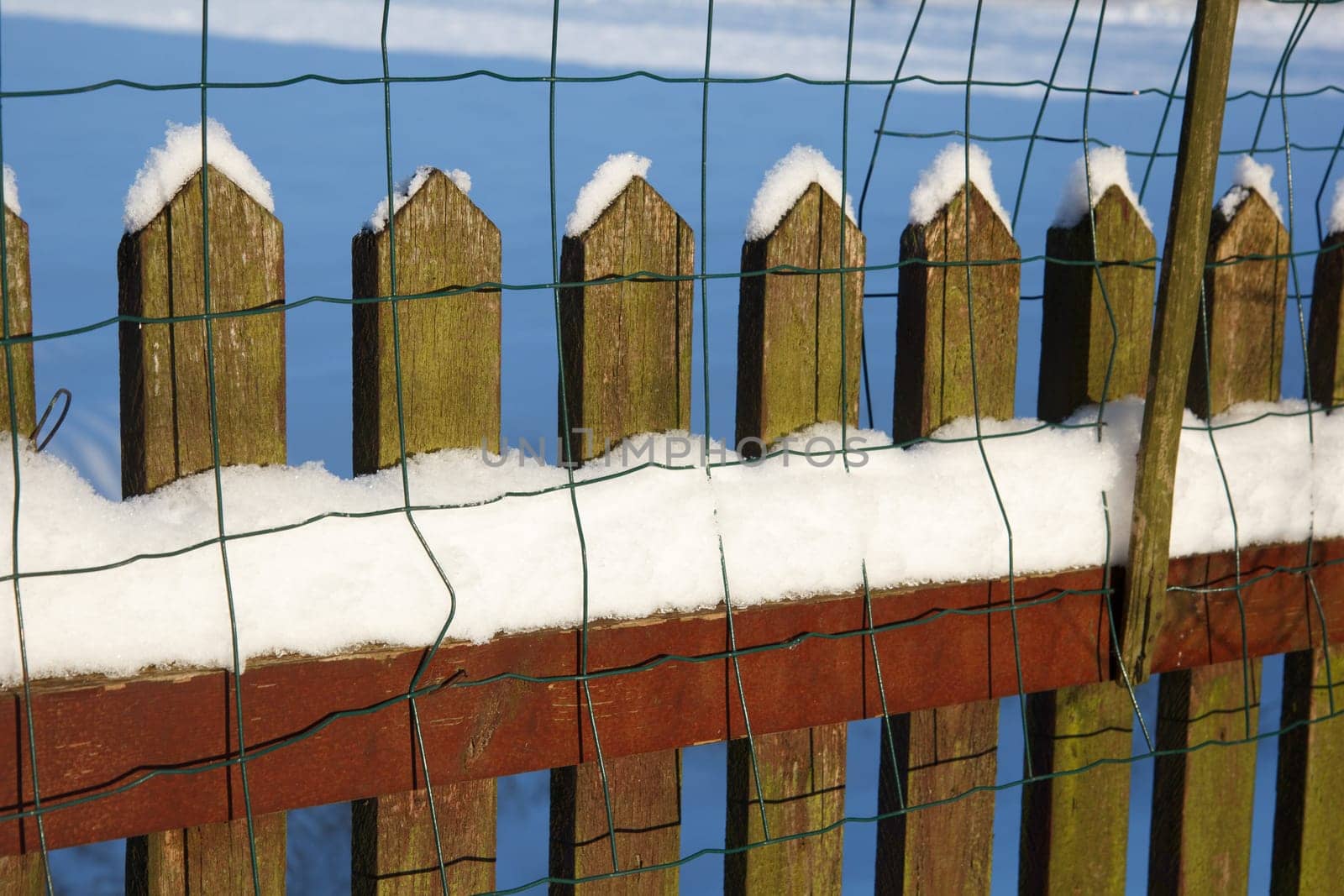 A wooden fence covered with white snow