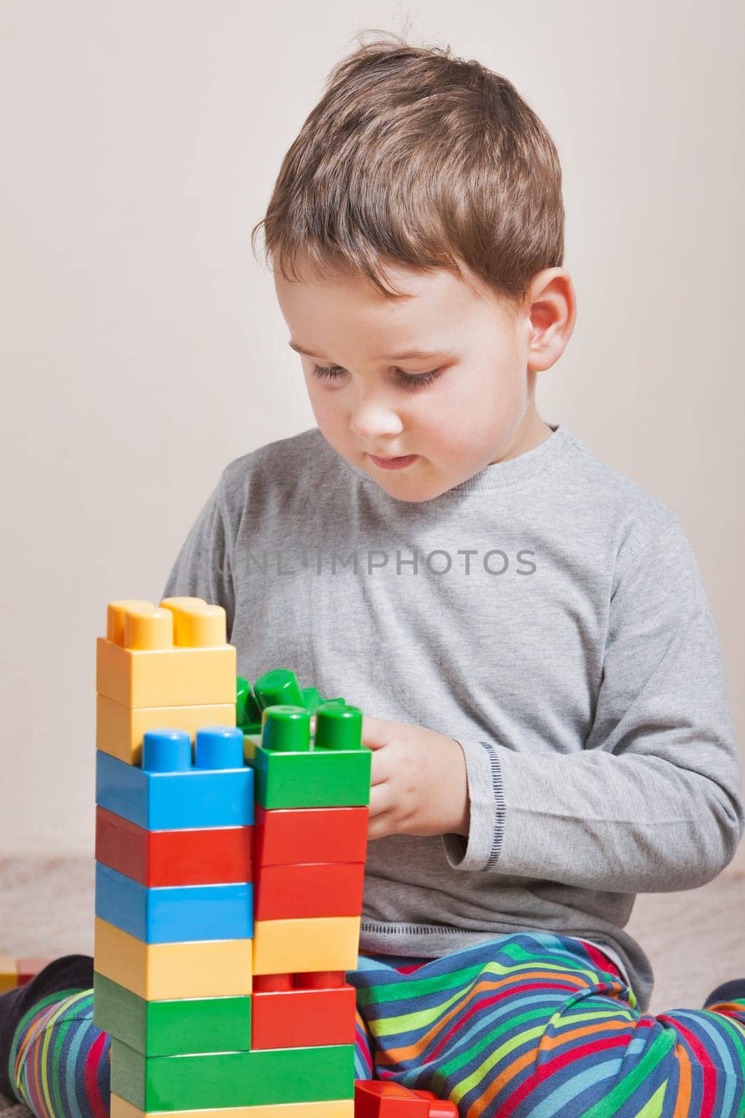 Playing little boy with colored cubes