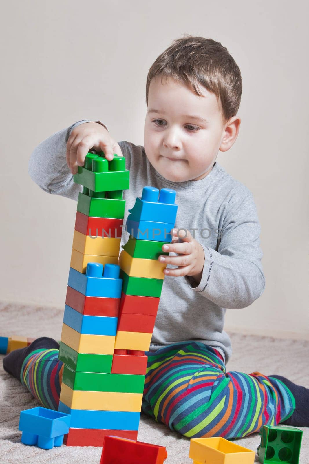 Playing little boy with colored cubes