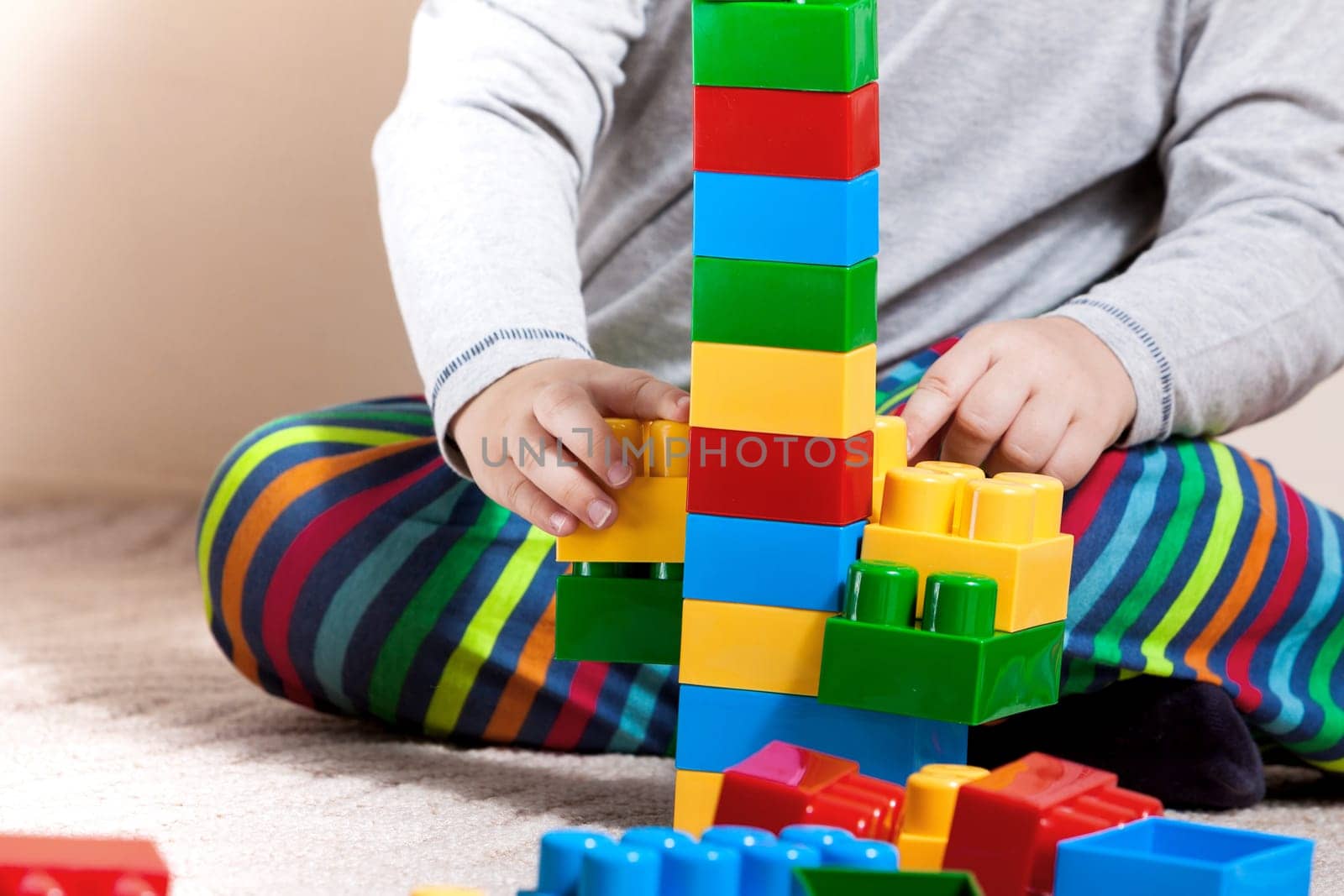 Playing little boy with colored cubes