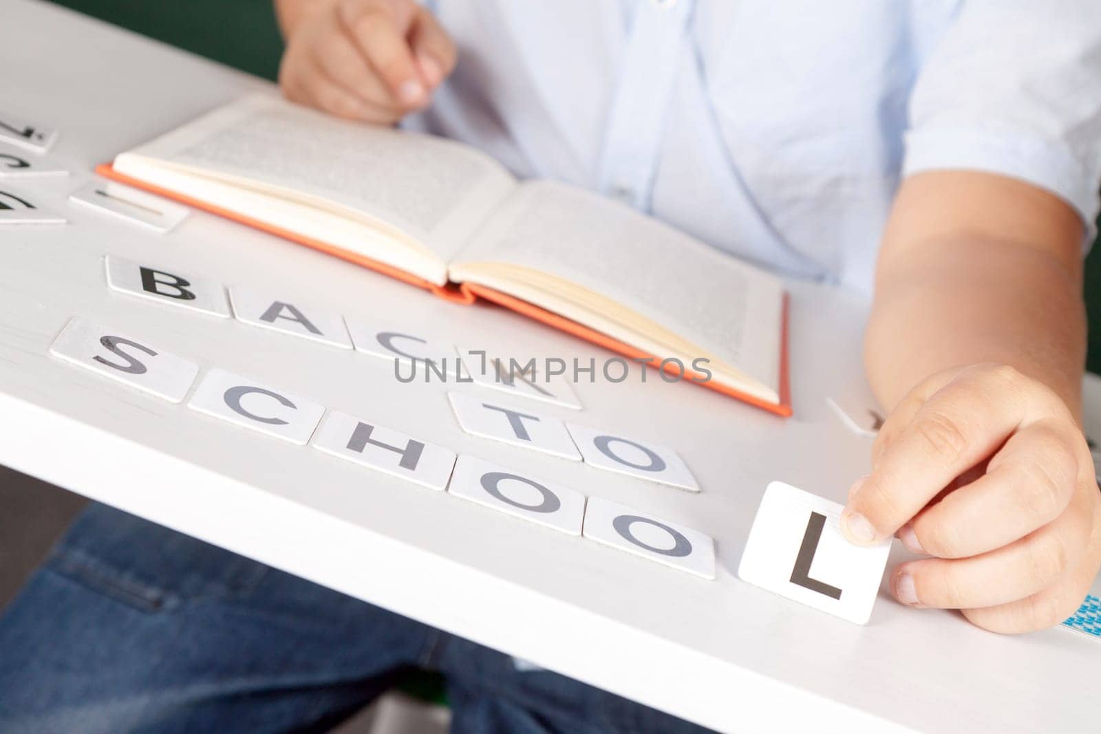 boy sitting at school desk with the inscription of the numbers back to school