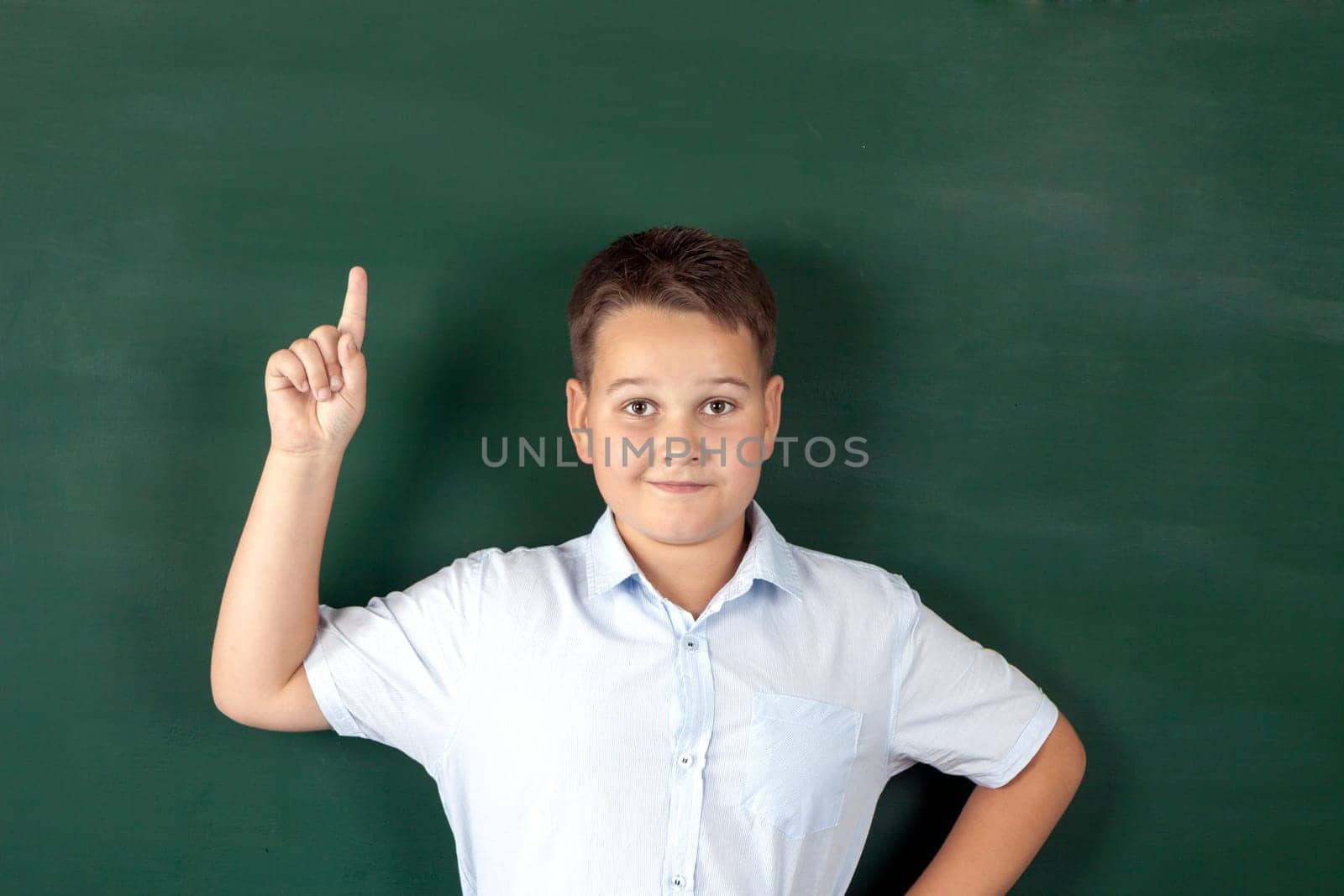 boy in a shirt with school boards with bulb and idea