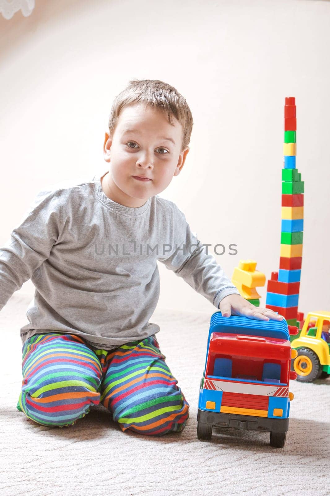 Playing little boy with colored cubes