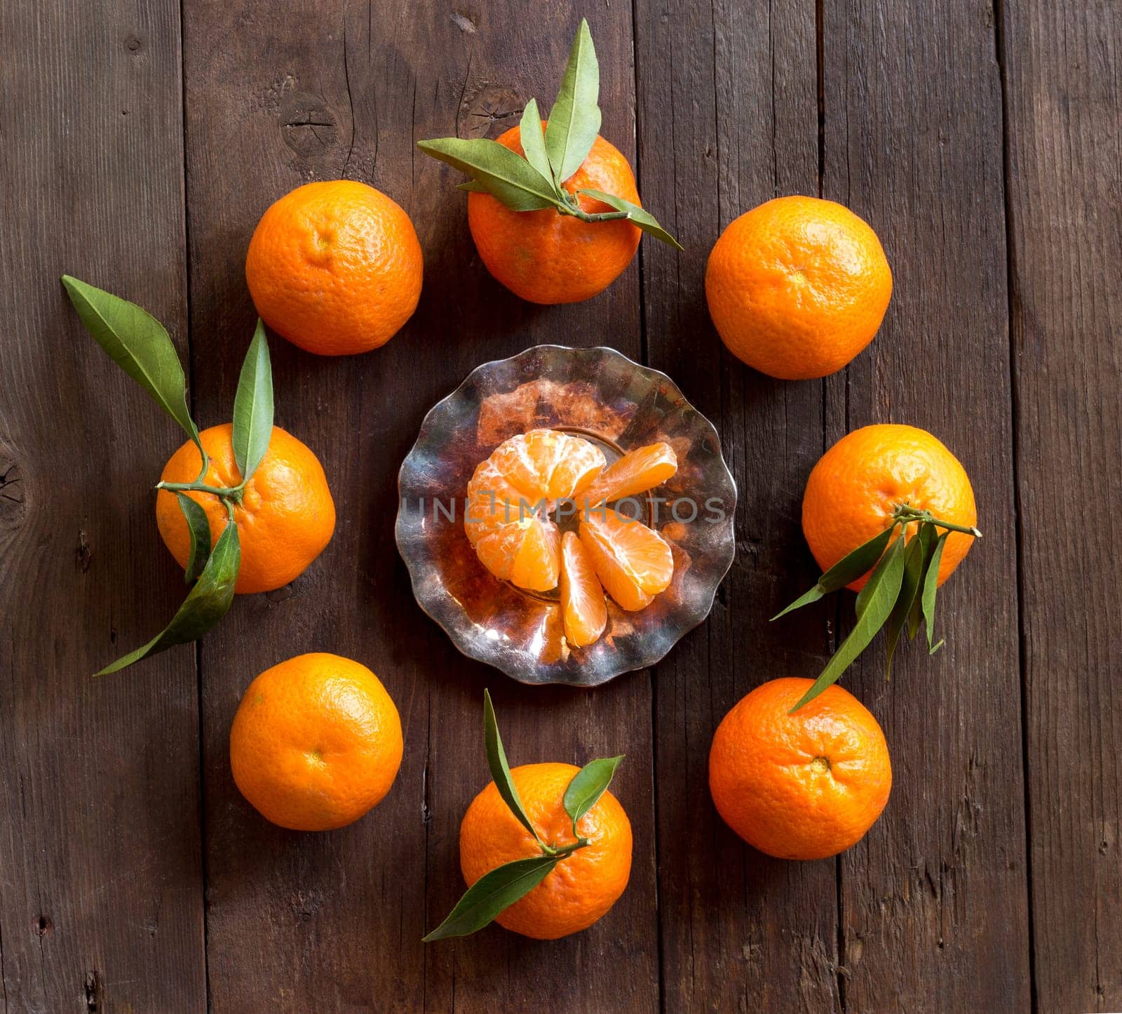 Fresh Tangerines with green leaves on a wooden background