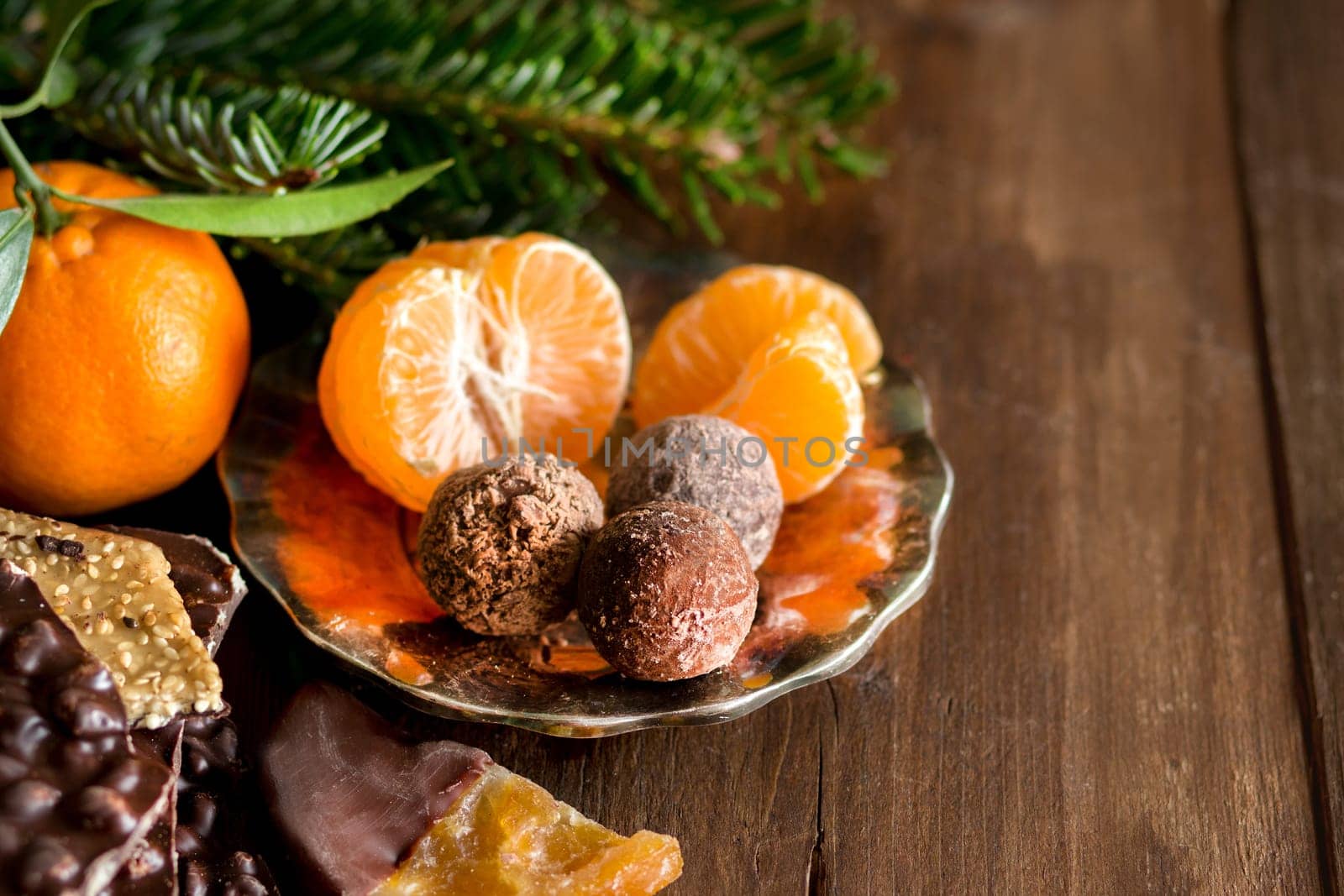 Chocolate, truffles and tangerins on a wooden table