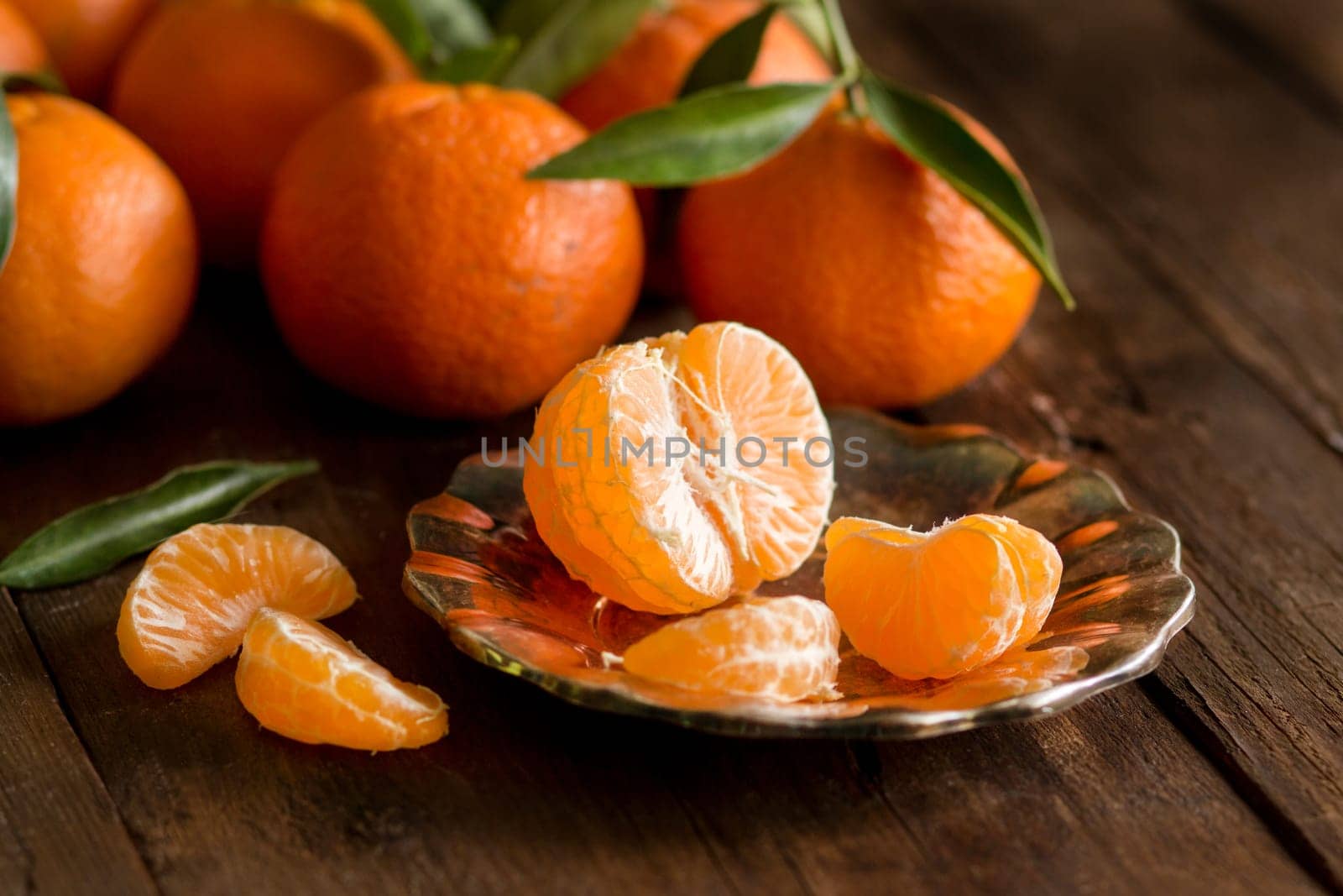 Fresh Tangerines with green leaves on a wooden background