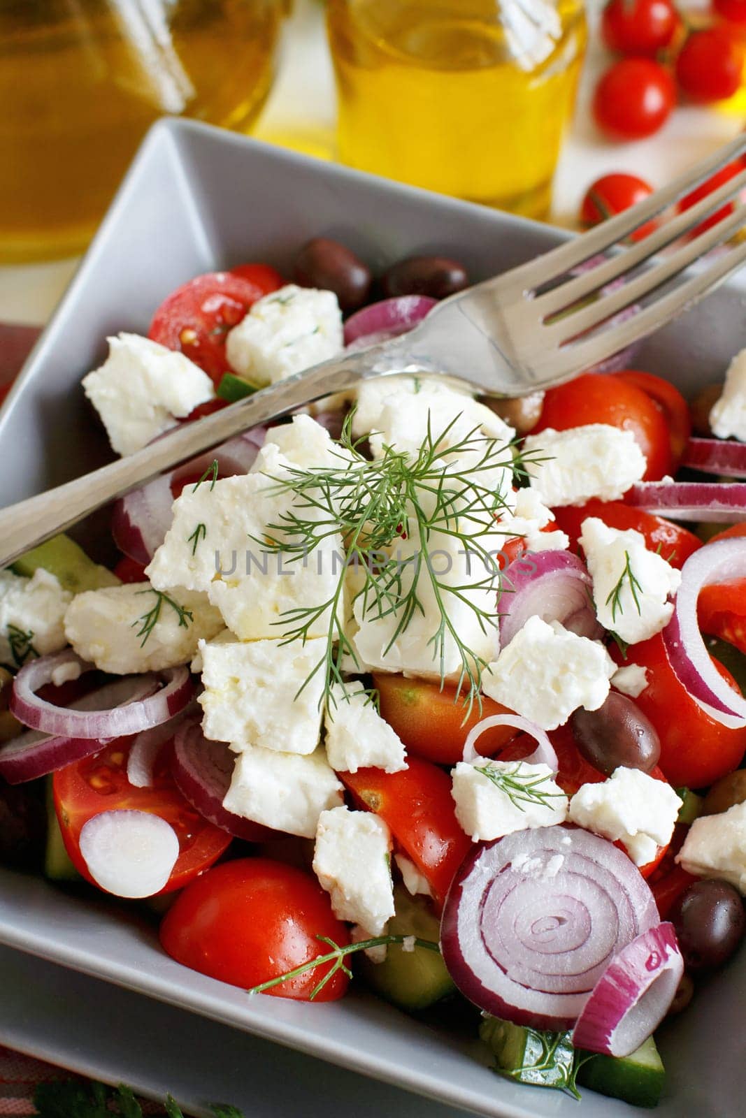 Greek salad with tomatoes, feta cheese, cucumbers, onions and olives