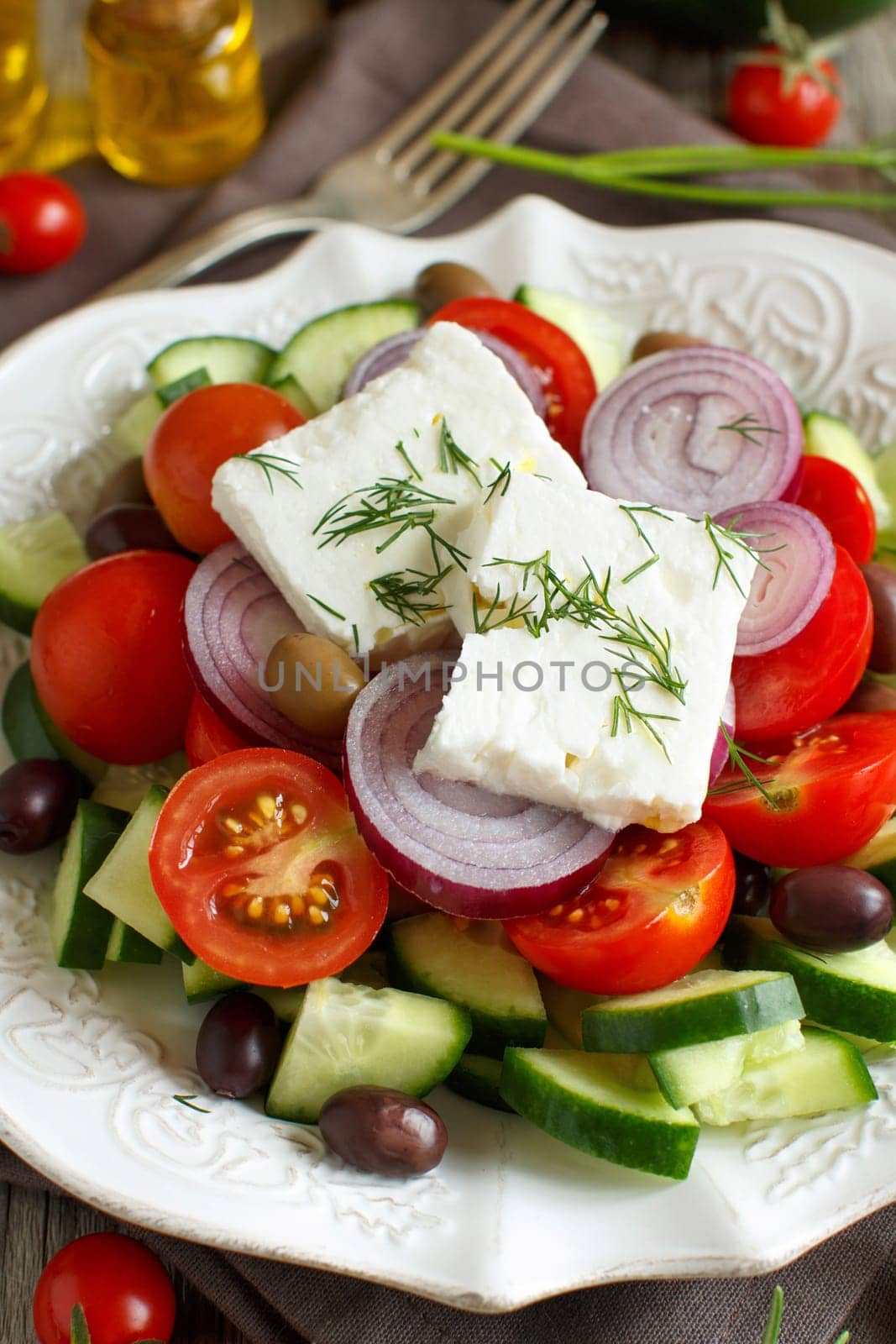Greek salad with tomatoes, feta cheese, cucumbers, onions and olives