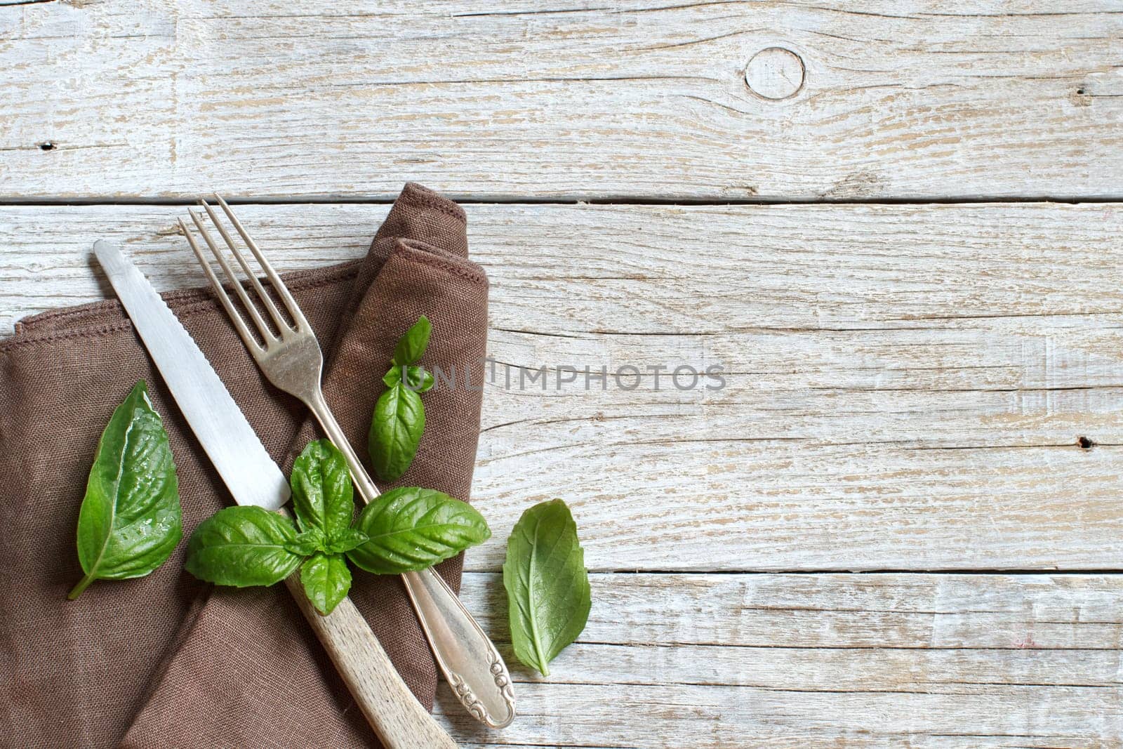 Vintage fork and knife on a napkin on a old wooden table