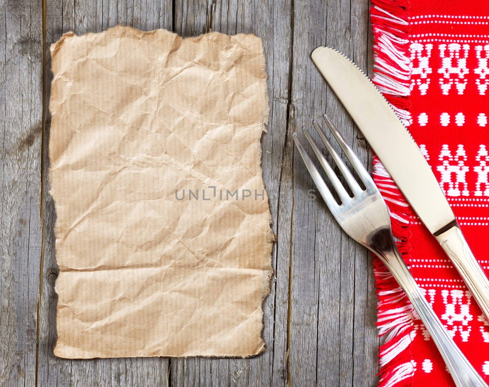 Fork and knife on kitchen towel and old wooden table
