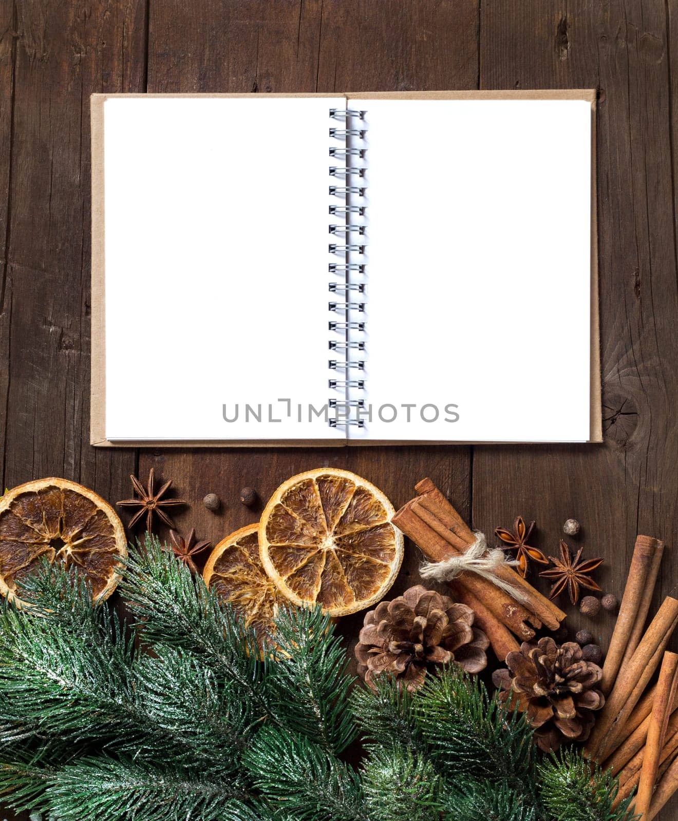 Christmas composition with spices and notebook on wood