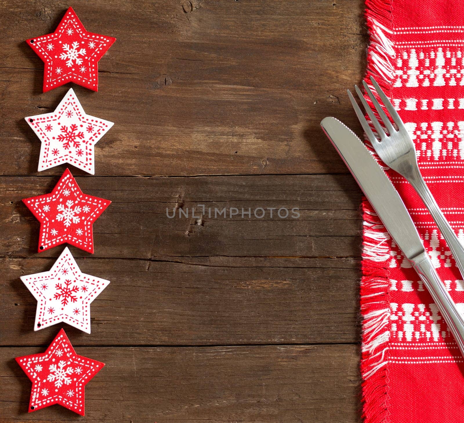Christmas Table background with red stars, red napkin, fork and knife