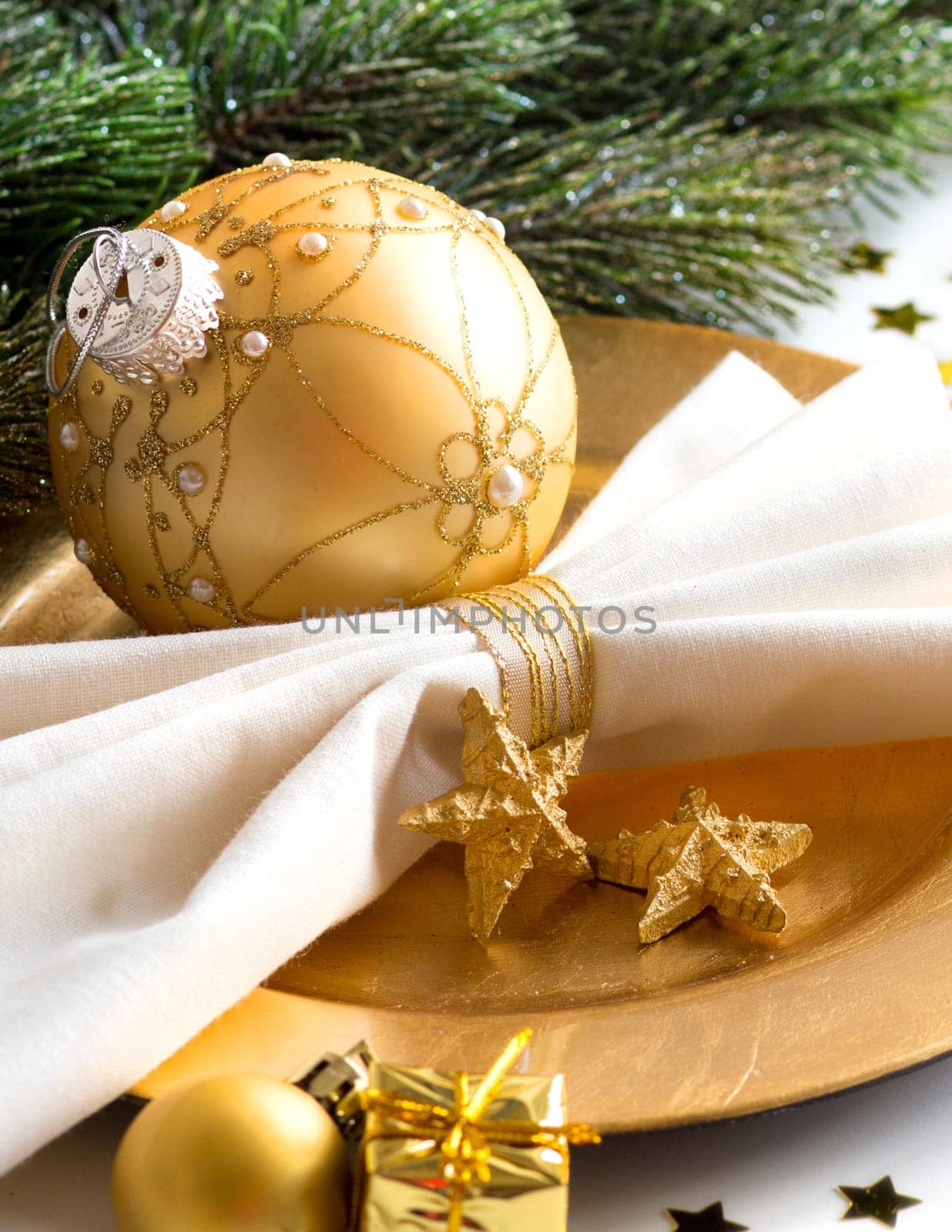 Festive table setting with golden bauble and plate