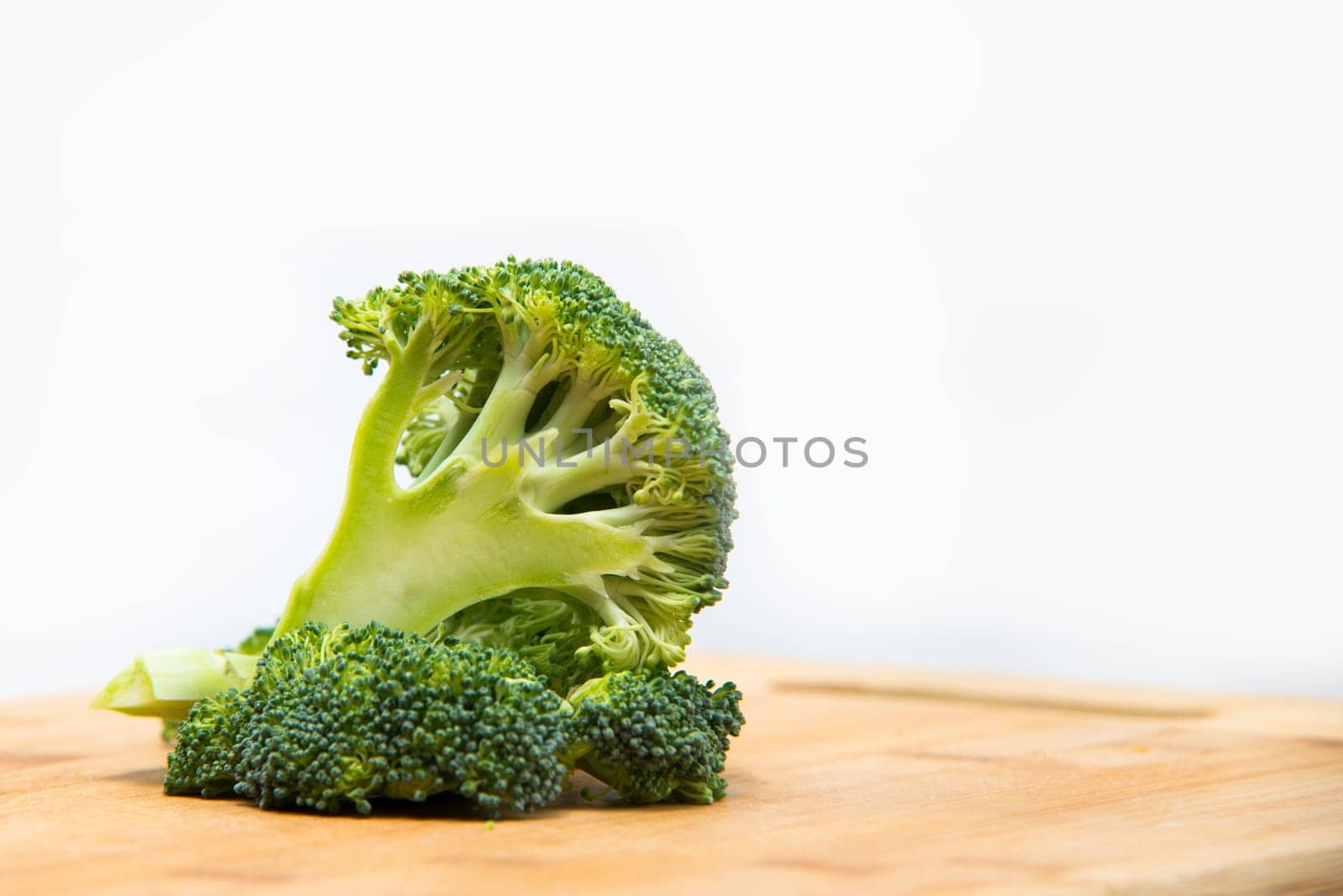 close up on fresh broccoli solated on wooden and white background