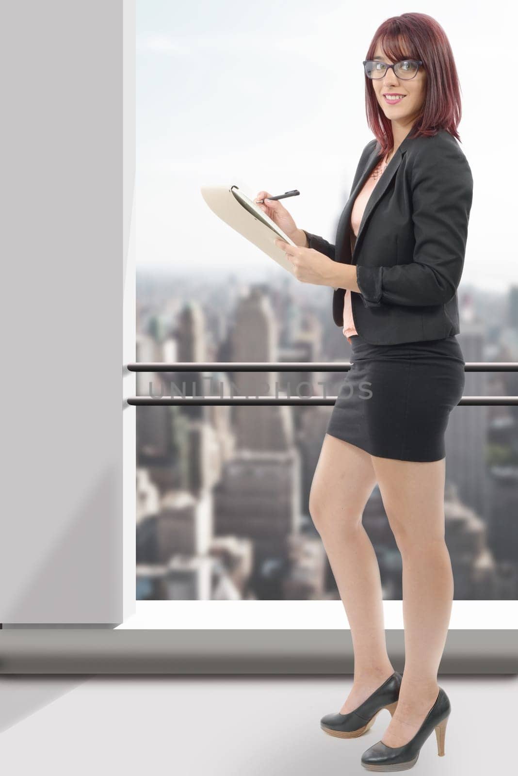 Cute young business woman smiling, in an office environment