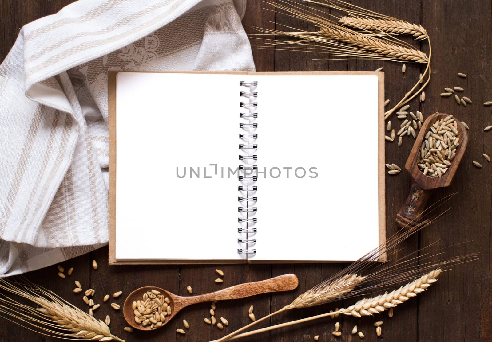 Notebook and wheat on a napkin with old wood background