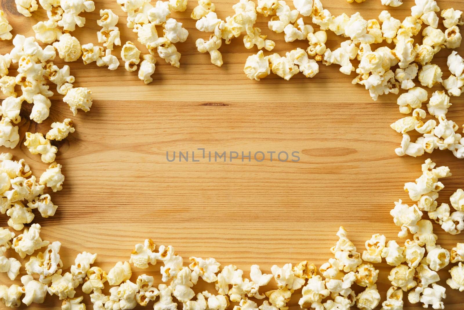 Frame of popcorn on wood background with copyspace