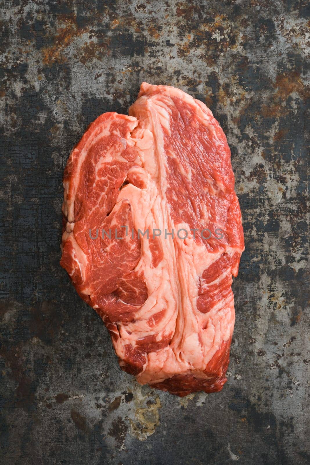 Chuck eye steak on dark rustic background