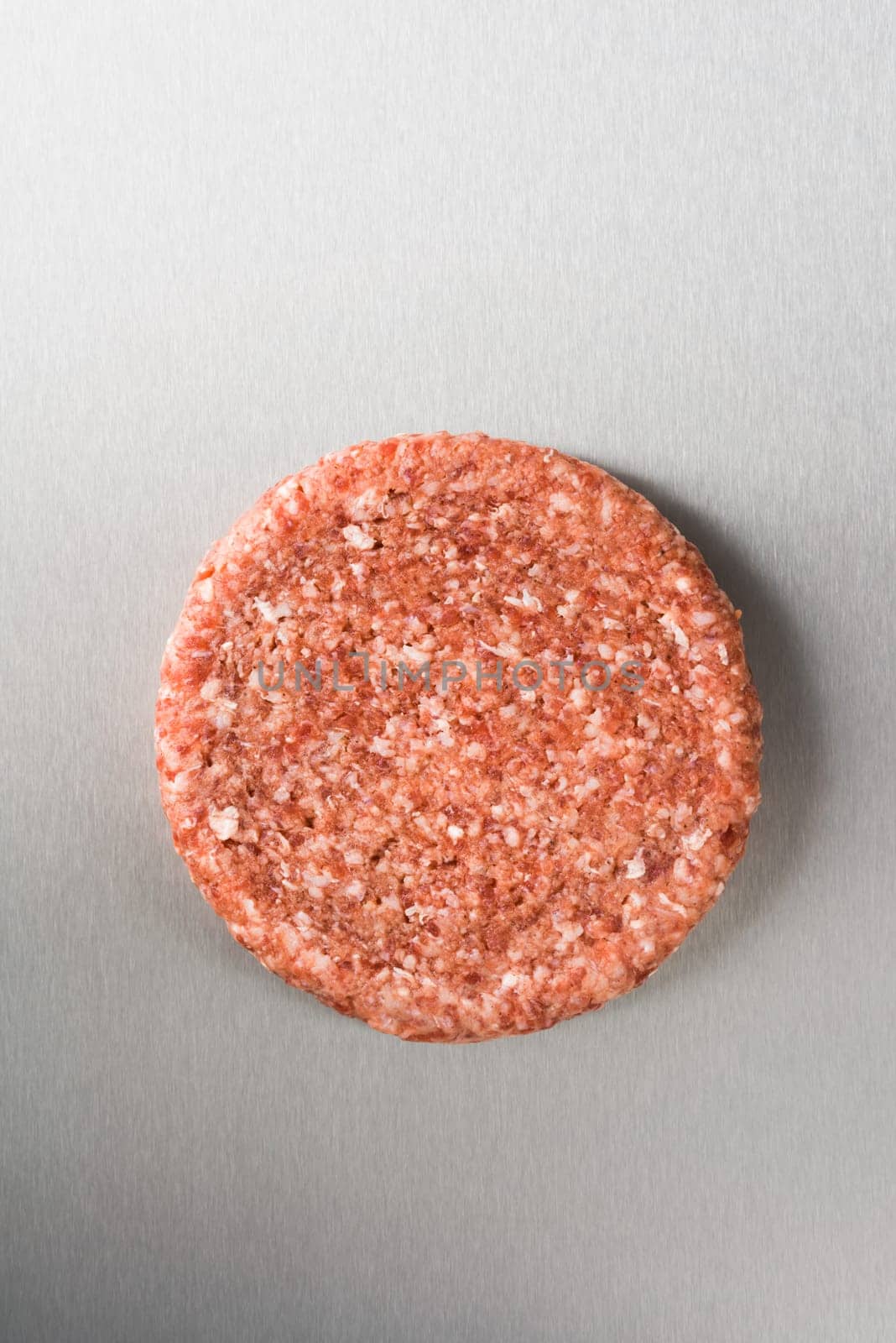 Burger patty from ground beef on stainless steel
