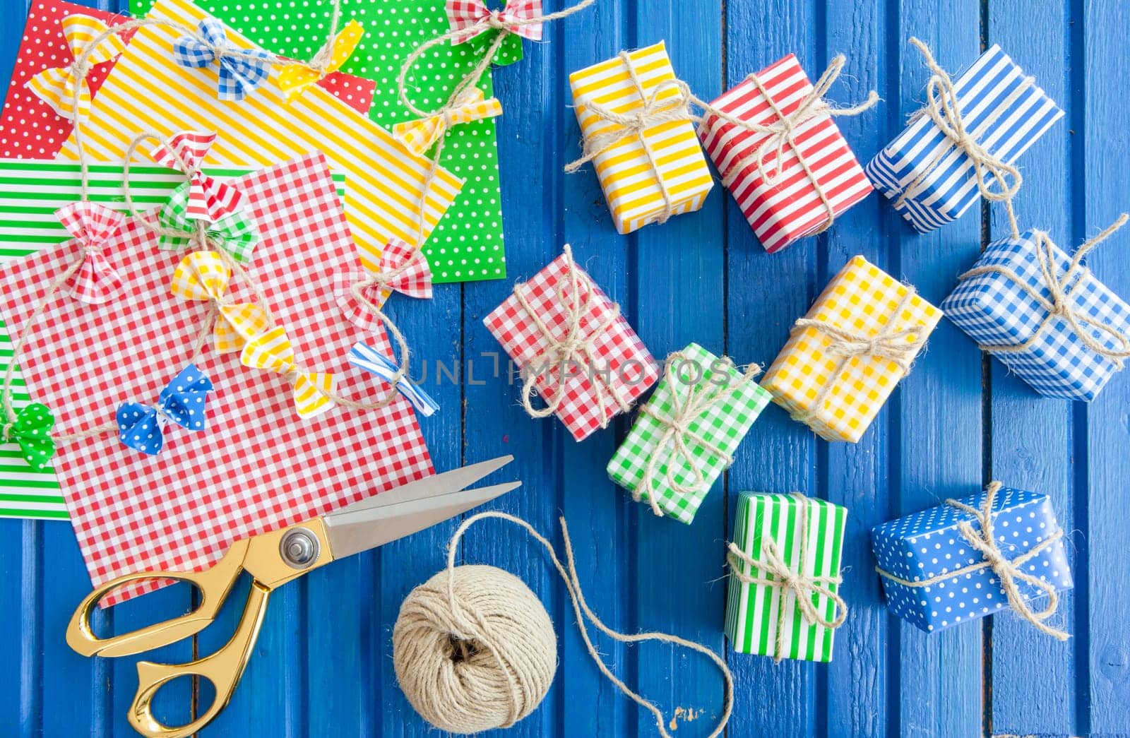Small colorful gifts on a rustic background of blue wood