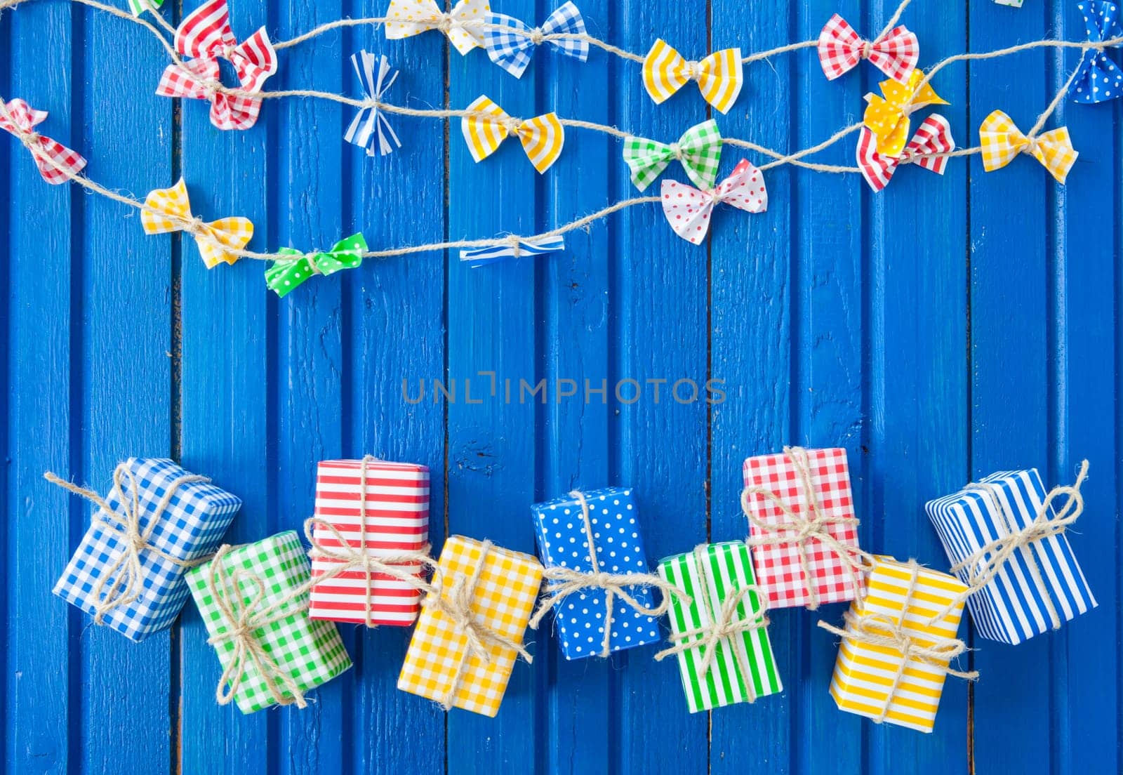 Small colorful gifts on a rustic background of blue wood