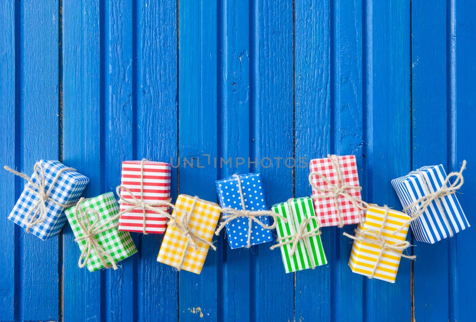 Small colorful gifts on a rustic background of blue wood