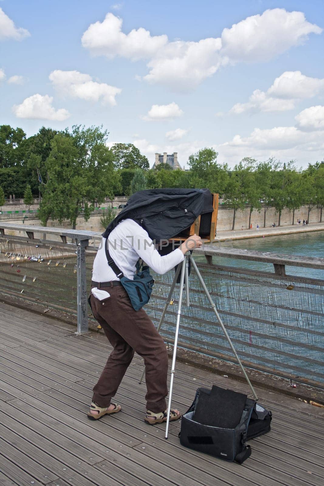 photographer with old plate camera on the seine bridge Passerelle Solferino in Paris