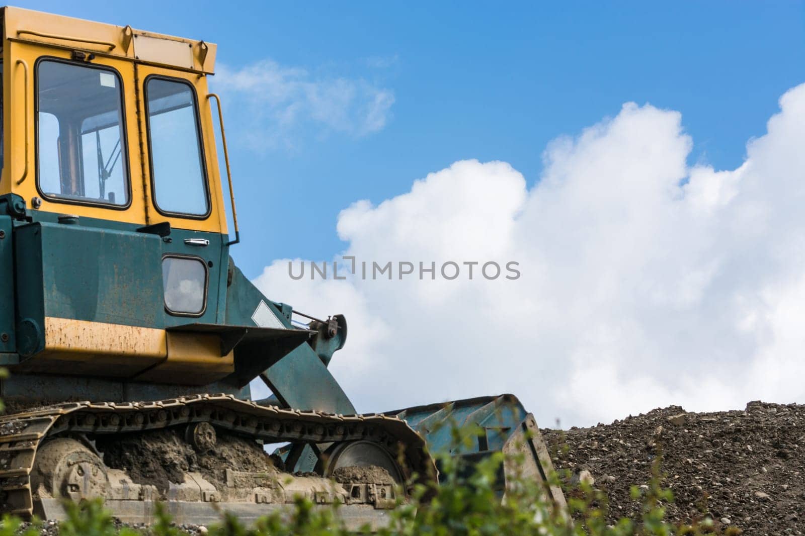 Excavator construction machine on a construction site in the background a blue sky..