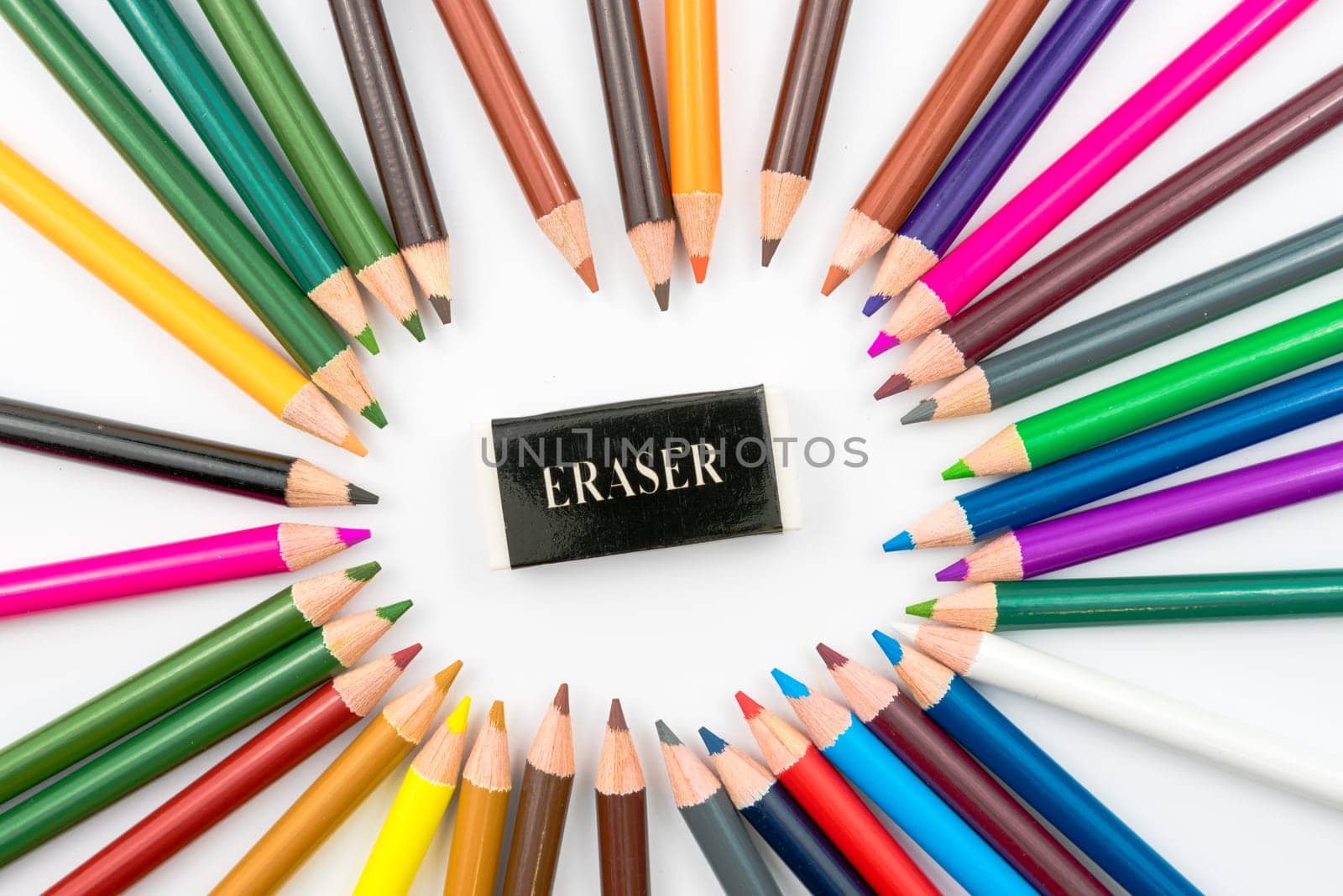Circle made of colouring pencils with eraser in middle isolated on white background,education concept image with copy space available