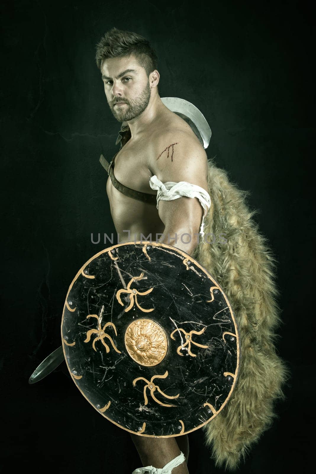 Ancient warrior or Gladiator posing over a dark background