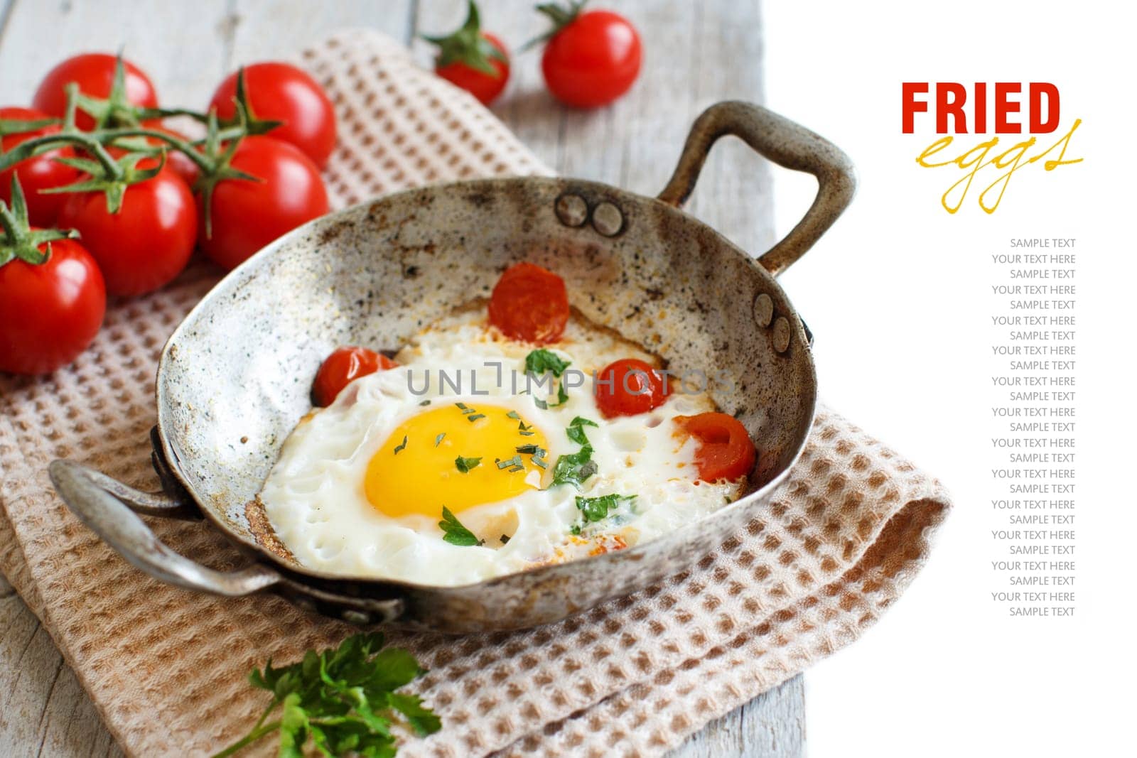 Fried egg with tomatoes and herbs on a old frying pan on wood