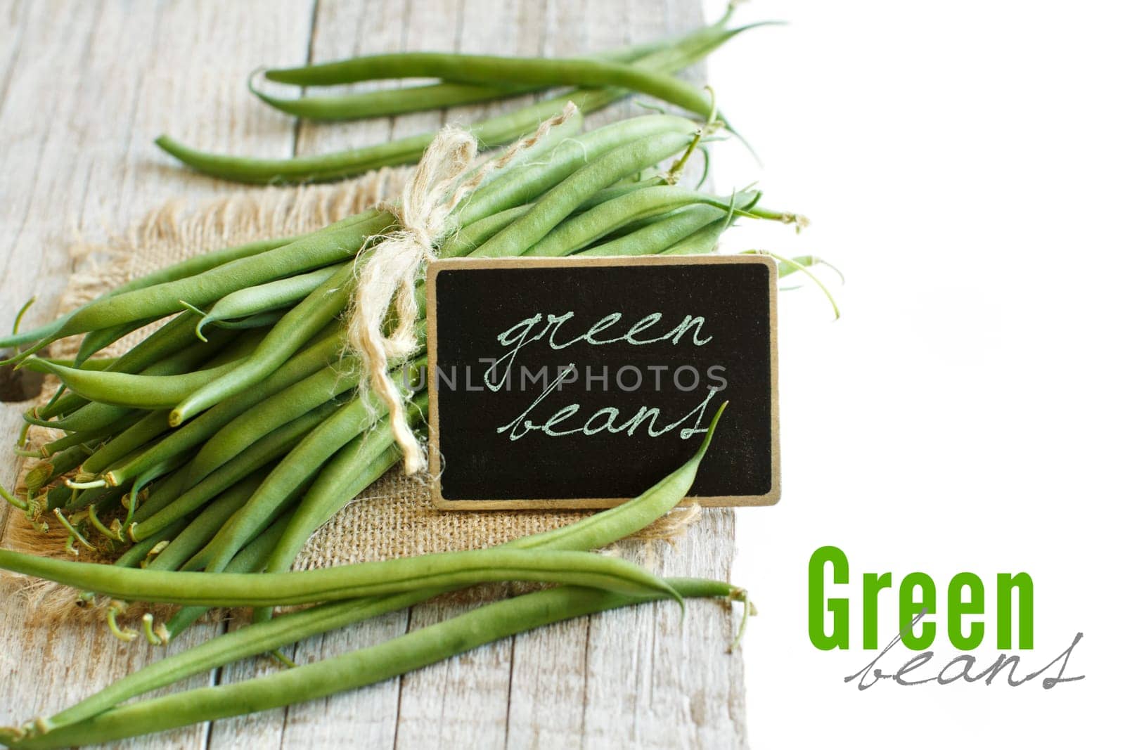 Fresh green french beans on a wooden background