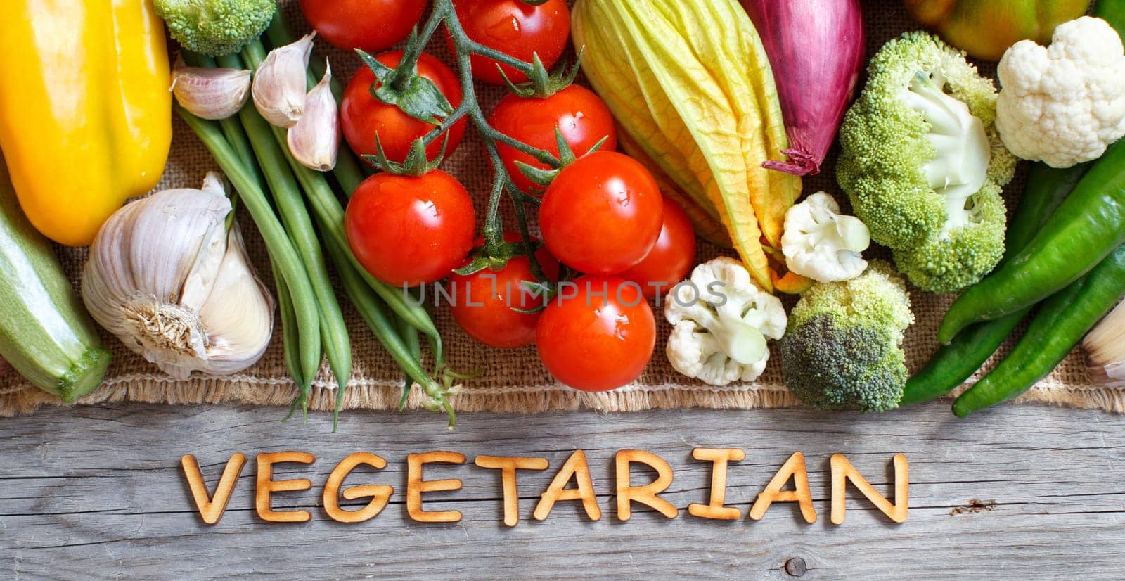 Fresh vegetables and wooden letters on an old wooden table