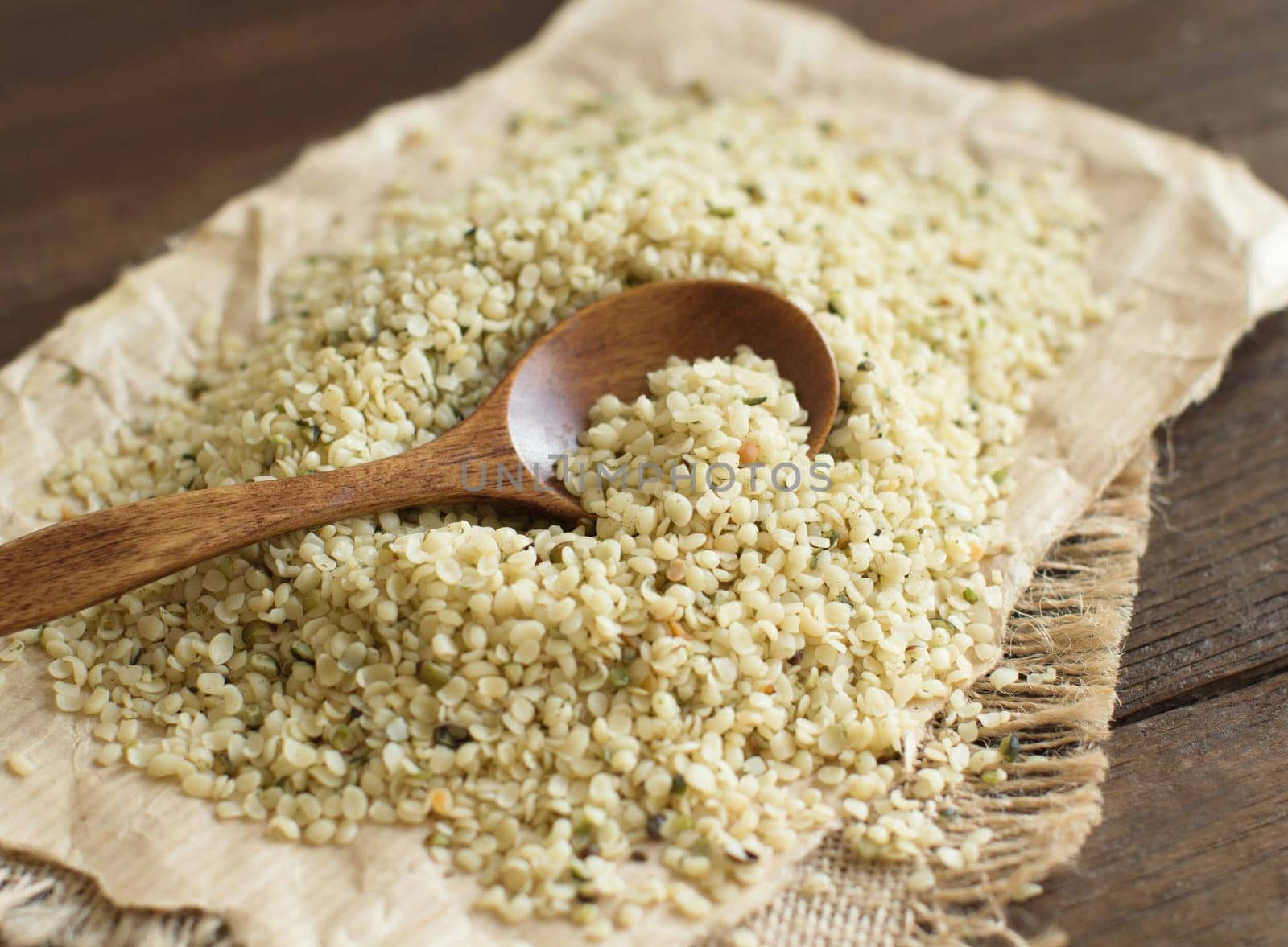 Hemp seeds with a spoon on wood close up