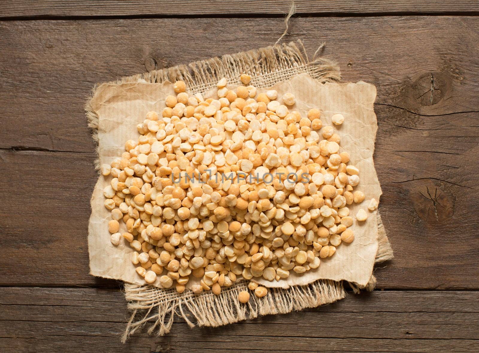 Pile of split yellow peas on wood close up