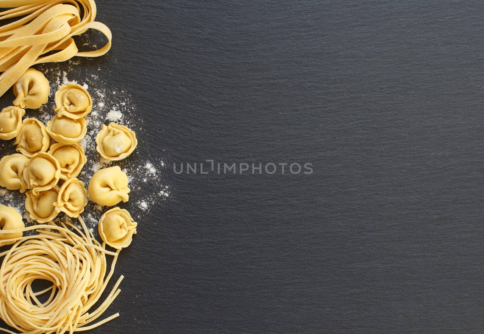 Fresh uncooked italian pasta on a dark background