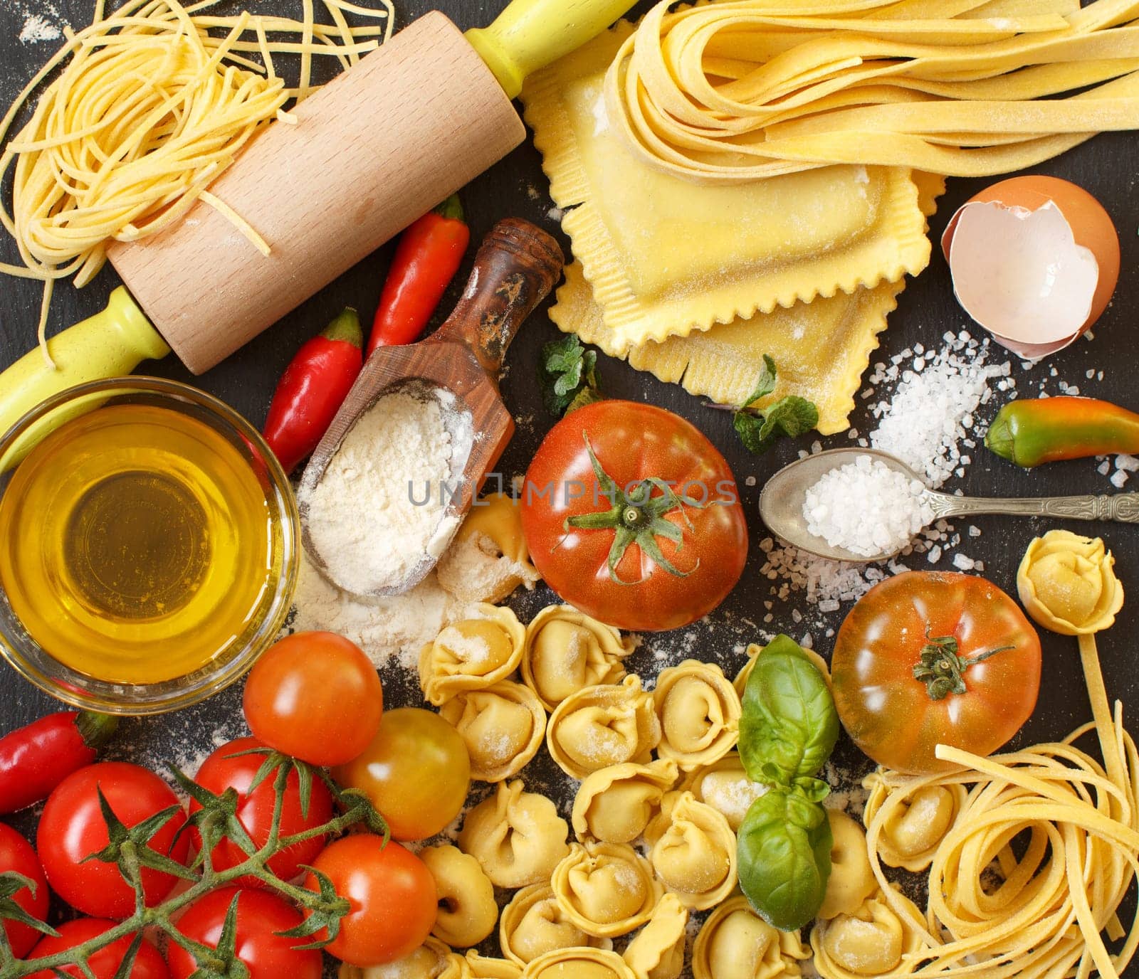 Fresh pasta and ingredients on a dark board