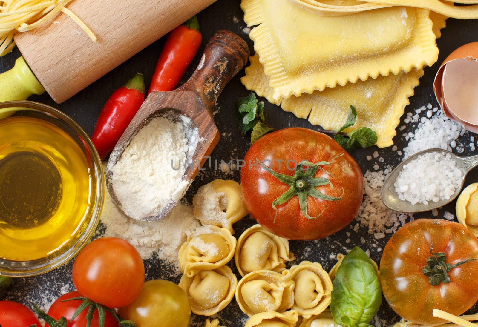 Fresh pasta and ingredients on a dark board