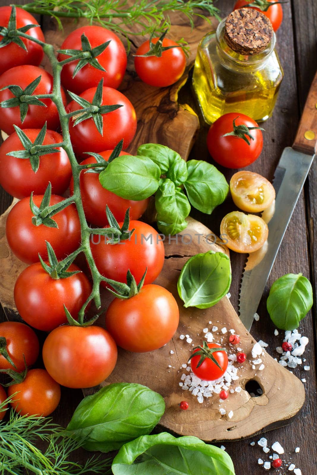 Cherry tomatoes, basil and olive oil on a wooden table