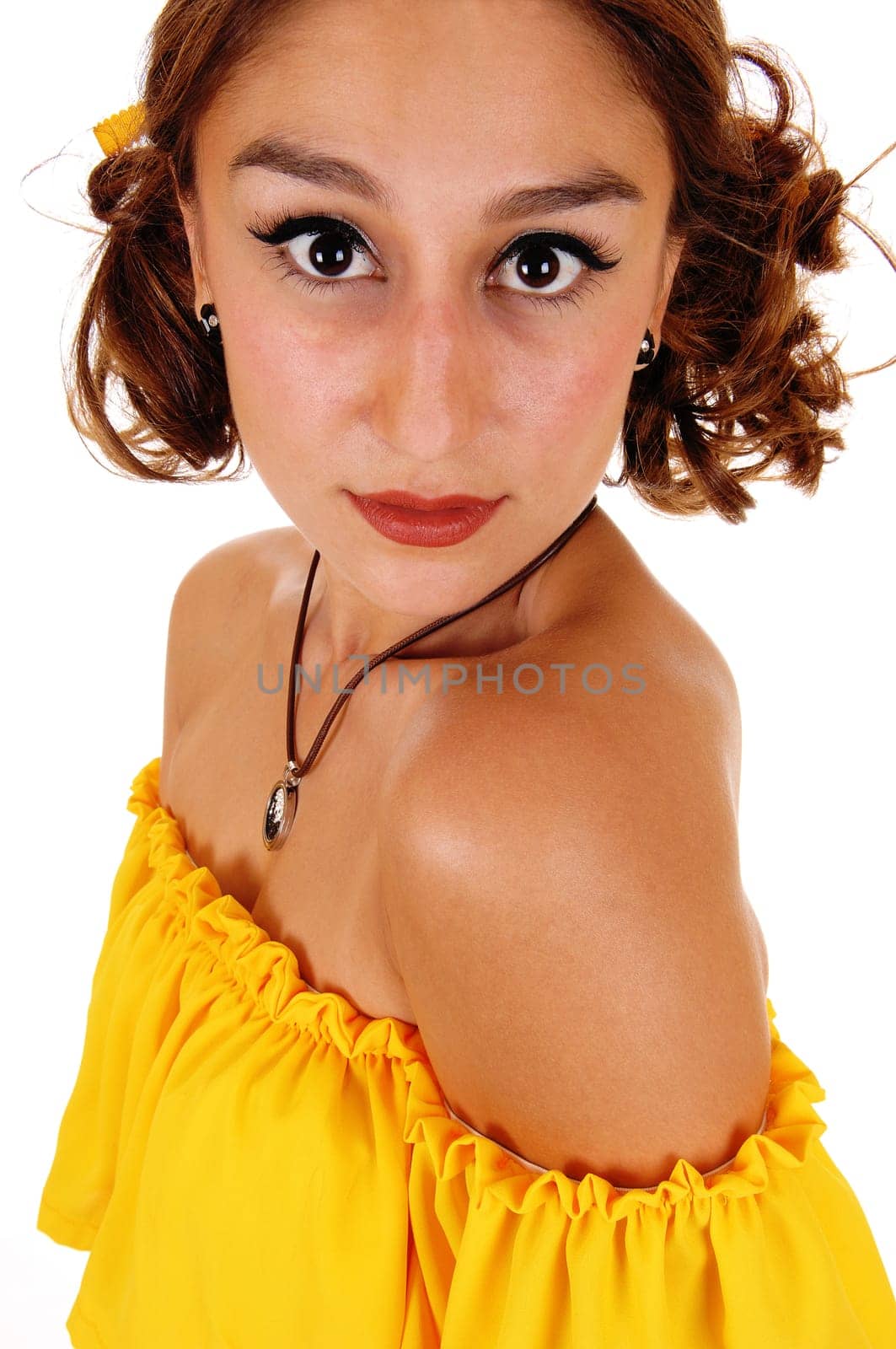 A lovely young woman with big eye's wearing a yellow blouse and .necklace looking strait into the camera, isolated on white..