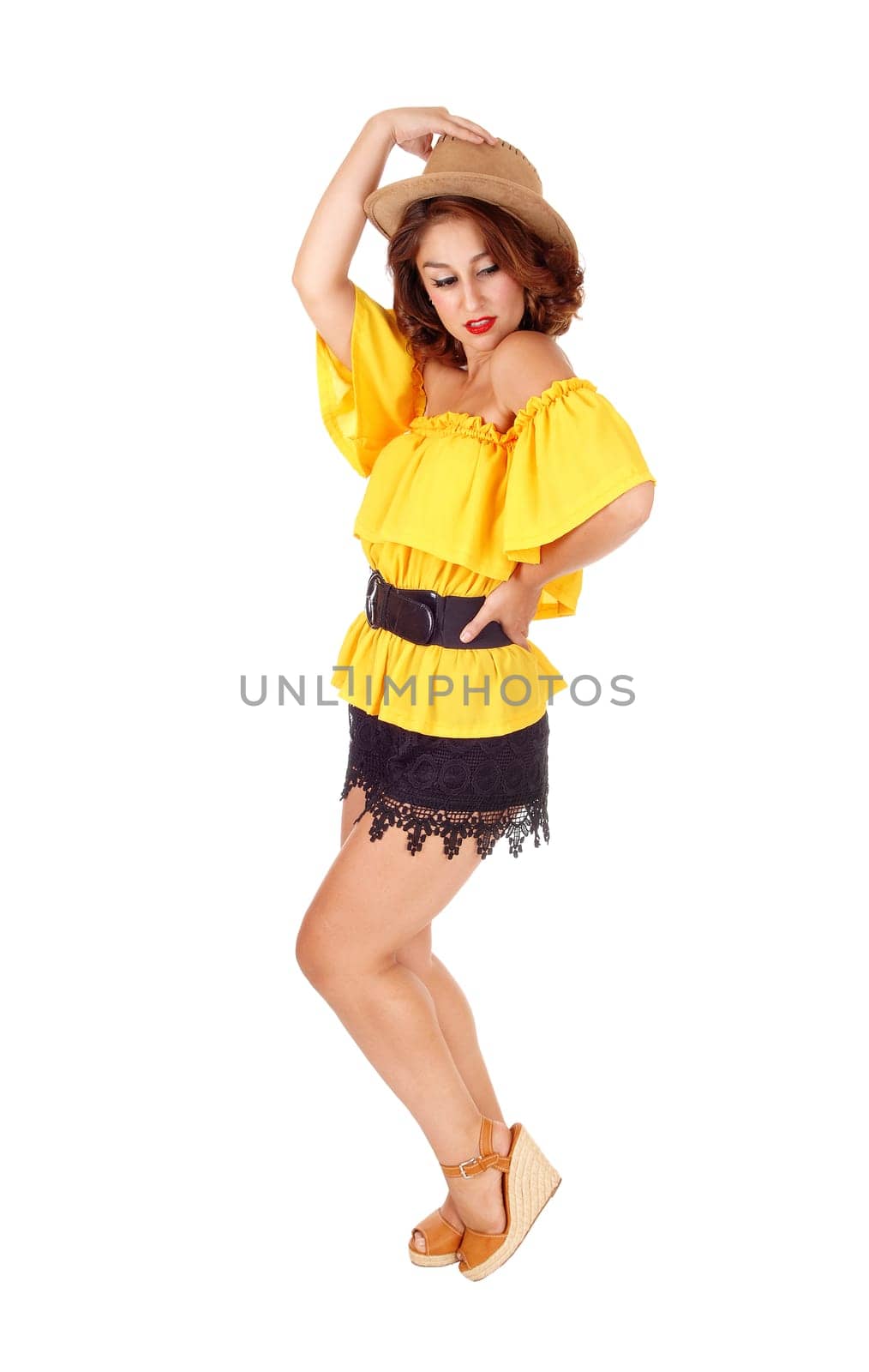 A lovely young woman posing in black shorts and yellow blouse with.a cowboy hat, isolated for white background..