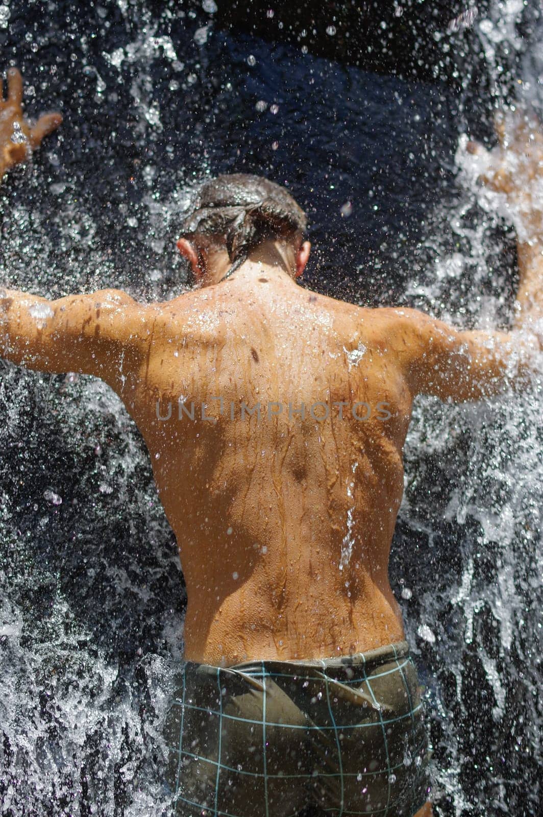 a man taking a relaxing shower under a waterfall outside