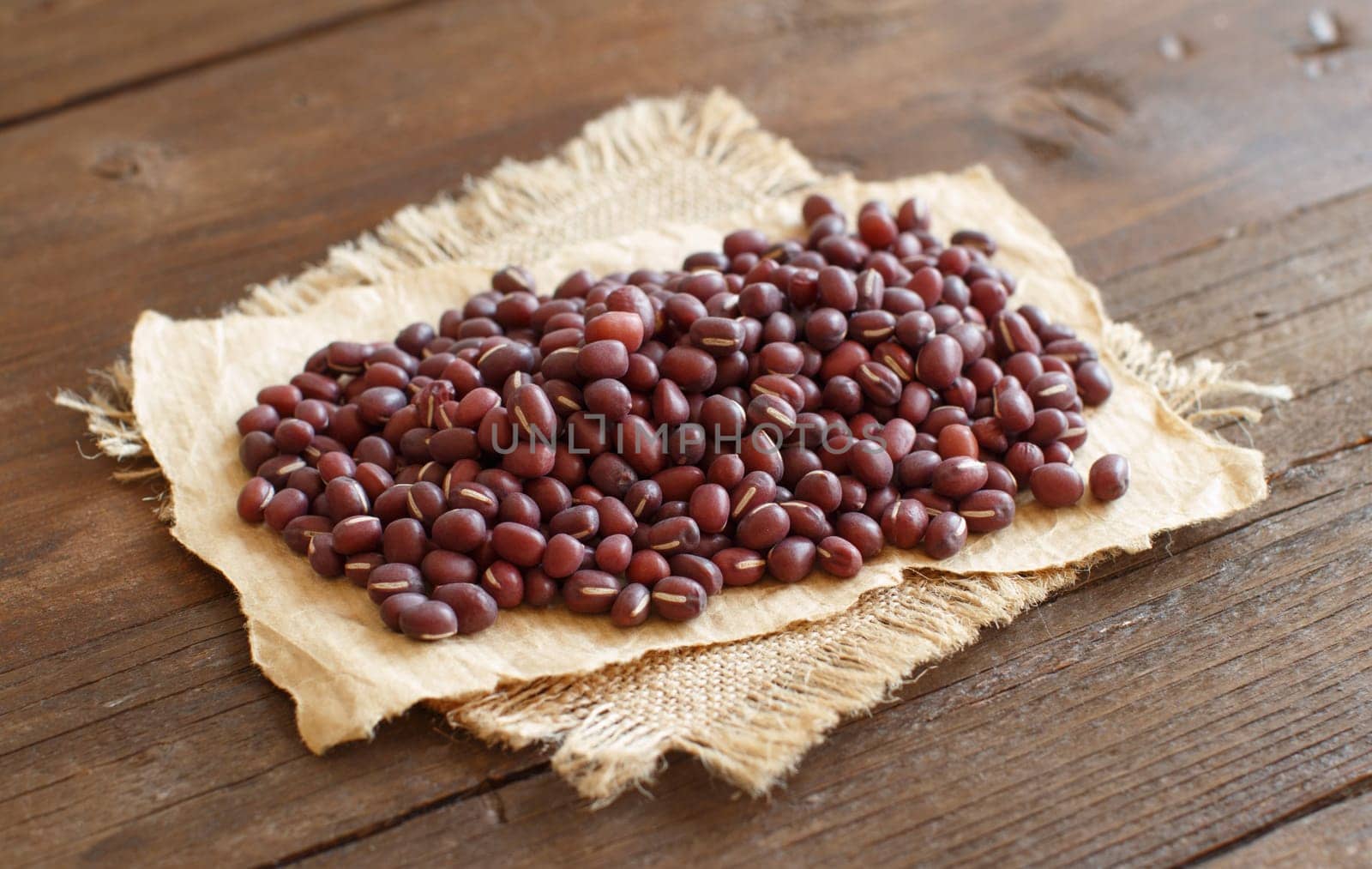 A pile of raw azuki beans on a wooden table