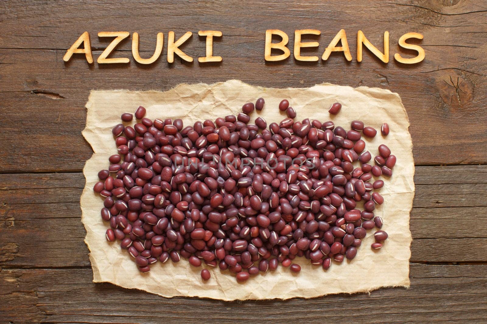 Raw azuki beans with wooden letters on a wooden table