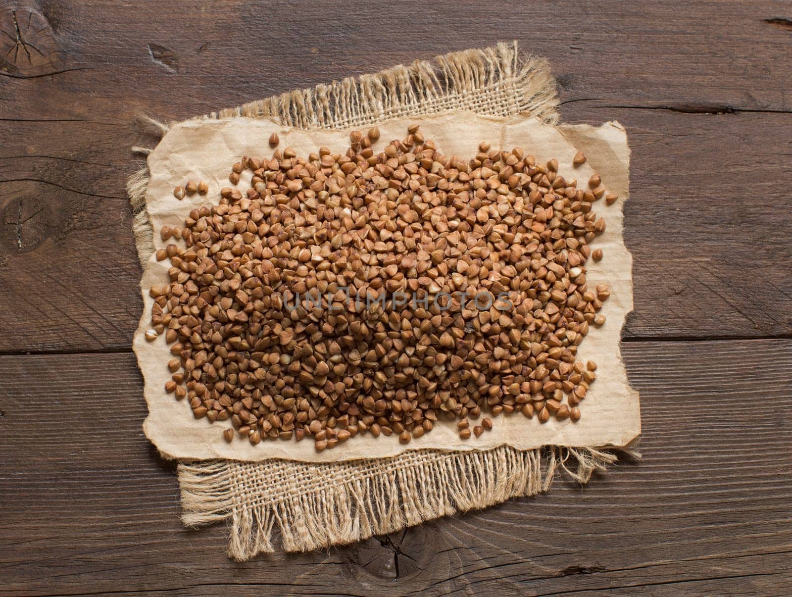 A pile of buckwheat on a wooden table top view